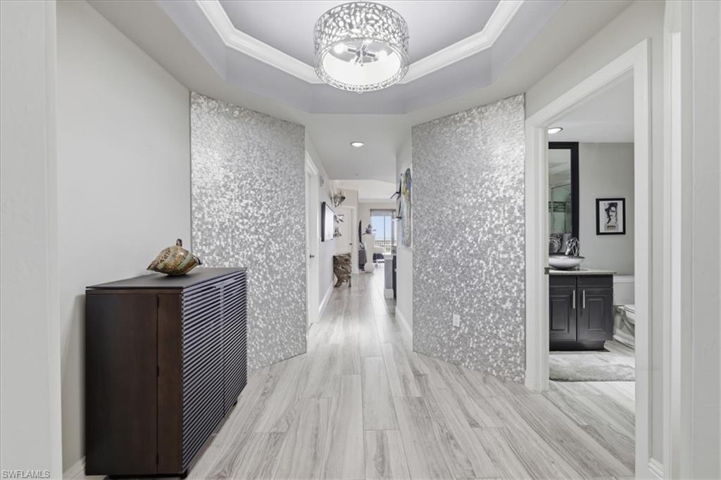 Welcome to luxury high-rise living at Riva Del Lago. Located on the **18th floor**, this beautifully updated residence showcases breathtaking panoramic views and a sophisticated blend of contemporary design and effortless comfort. Enjoy PRIVATE direct access to Lakes Park. 

Step inside to discover an open-concept floor plan featuring plank flooring throughout, elegant tray ceilings with crown molding, designer lighting, and expansive impact-resistant windows that fill the home with natural light. The gourmet kitchen is the centerpiece of the home, boasting dramatic granite countertops with a full-height matching backsplash, upgraded dark cabinetry, stainless steel appliances, built-in wall oven and microwave, an oversized breakfast bar, and abundant storage—perfect for entertaining.

The spacious living and dining areas seamlessly extend to the private screened balcony, creating the ideal indoor-outdoor living experience while capturing spectacular views of the Caloosahatchee River, Lakes Regional Park, and the surrounding Southwest Florida skyline.

Residents of Reva Del Lago enjoy an exceptional collection of resort-style amenities, including a lakeside infinity-edge pool and spa, fitness center, library, social room, secured lobby, billards/party room, and covered parking. Conveniently located just minutes from Gulf Coast Town Center, FGCU, RSW International Airport, dining, shopping, golf, and Southwest Florida's beautiful beaches.

Experience maintenance-free luxury living with designer finishes, incredible views, and unmatched amenities in one of Southwest Florida's premier high-rise communities.