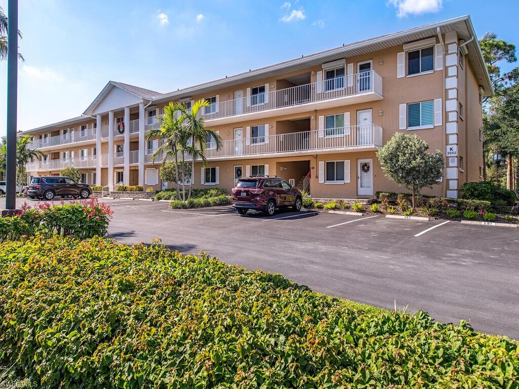 Lovely 2 bedroom, 2 bath condo located on the 3rd floor. This end-unit offers privacy and a serene setting overlooking tropical vegetation and slash pine trees. Close to the clubhouse and larger of the two community pools. Parking space located near stairwell leading to the condo. You will enjoy the natural light throughout the condo. New elevator was installed in building K in November 2022. Previously renovated kitchen with beautiful oak kitchen cabinets, large oak pantry, quartz countertops, new LG SS range, refrigerator, microwave, and Bosch dishwasher in 2022, eat-in bar framed in oak wood. Master and guest bathroom showers also renovated with glass doors, granite, gorgeous stone shower flooring and Moen finishes. Carrier HVAC installed 2019, surge protector in electric panel and A/C condenser. A/C can be monitored remotely. Smoke detectors installed in 2022. Laundry room offers extra storage space with a new LG washer/dryer in 2022. Lawson front door with pull down screen is perfect for summer breezes, sliding pocket doors seamlessly transition you to the great outdoors. Close to 5th Avenue shopping and restaurants and Naples beaches.  Make this your fun in the sun home!
