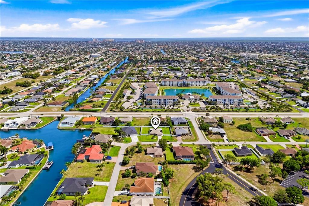 TURNKEY FURNISHED and moved-in ready, this exceptional SOUTHWEST Cape Coral estate is the total package! Situated on a rare FENCED TRIPLE LOT spanning .37 acres, this property delivers unmatched privacy, space, and lifestyle. PAID-OFF SOLAR PANELS, ALL ASSESSMENTS PAID, and complete IMPACT WINDOWS & DOORS throughout. Step inside to a bright, open-concept great room with soaring vaulted ceilings and a stunning FULLY REMODELED CHEF'S KITCHEN featuring a massive center island, granite countertops, pull-out cabinetry, and newer appliances (2021). Custom professional closet systems and garage storage maximize organization and functionality. The oversized homesite is perfectly positioned to allow 10-foot gate access on BOTH sides—ideal for boats, RVs, trailers, or all your recreational toys. Outside, discover your own private resort. The SOUTH-FACING SALTWATER POOL and expansive screened lanai create the ultimate year-round outdoor living experience, with multiple entertaining areas, lush, manicured grounds, a fire pit, and endless room for gatherings, recreation, or future additions.  Better than new and loaded with upgrades, this home checks every box. Rarely does a property offer this combination of location, land, efficiency, luxury, and value. A true 10 out of 10!