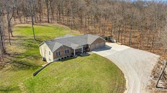 Gorgeous ranch situated on nearly 5 acres of private land! Custom built home has a beautiful stamped concrete porch walking up to the front door. Open the door to an expansive living room w/ vaulted ceilings. Just beyond the living room is the open kitchen with center island & breakfast bar. You'll also see your formal dining area sitting on hardwood floors that leads out to another stamped concrete patio, measuring 21 ft x 21 ft (great for outdoor entertaining and BBQ's). All the bedrooms are on the main floor; master suite is large with a spacious walk-in closet & his/her sink. The basement offers plenty of storage space, a rough in for another bathroom and the possibility of an additional bedroom. The possibilities are endless with a walk-out basement. There is a finished safe room already in place! The wood stove keeps the electric bill low during the winter months. Bonus - 3 car over-sized garage plus additional parking space! Come check out the features of this impressive ranch! Additional Rooms: Mud Room