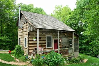 You'll think you are in the Smoky Mountains on this gently rolling, wooded, secluded 10 acres with creek and German-style 1860's log cabin with frame addition added in 2006. Peaceful setting with abundant wildlife.  Main level consists of living room with woodstove, kitchen with granite countertop, stainless steel electric stove and refrigerator, dining nook, bathroom with oversized Jacuzzi tub, upper level loft bedroom overlooking living room. Attic storage room off bedroom.  Basement under addition.  Enjoy relaxing on the 18' x 8' covered front porch, gathering around the fire pit or strolling through your private woodland paradise.   Central air & electric heat.  Previously operated as a B & B under a conditional use permit from Warren County.  Please consult with Warren County for more information if you wish to do the same. Suitable for Bed/Brk