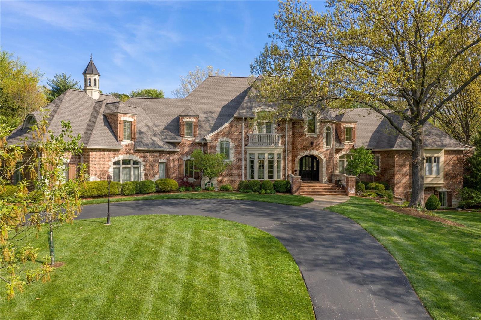 Exclusive Ladue offering sitting on almost 2 acres. Almost 8,000 square feet on the main 2 floors. The perfect balance of traditional & modern updates. Stunning hardwoods & soaring ceilings throughout main floor. Gourmet Kitchen has everything you need w/ center island, custom finishes & adjoining breakfast & hearth rm. Bright & Airy sunroom off kitchen. Breathtaking great rm w/ window wall & wet bar. Home flooded w/ natural light. Expansive Owner's Suite on main floor w/ sitting area, fireplace, his/her closets & bathrooms & french doors to patio. Main floor includes 2 separate office areas, 2 laundries & additional baths. Upper-level feat. 3 ensuite BR's + Huge bonus rm w/ half bath for possible 4th ensuite on second flr. LL includes family rm, additional ensuite BR, bar, & wine cellar. This home is in immaculate condition. Exterior includes separate pool area & tremendous amount of green space. Oversized 4 car garage! This home is an entertainer's dream of uncompromising quality. Additional Rooms: Mud Room, Sun Room, Wine Cellar