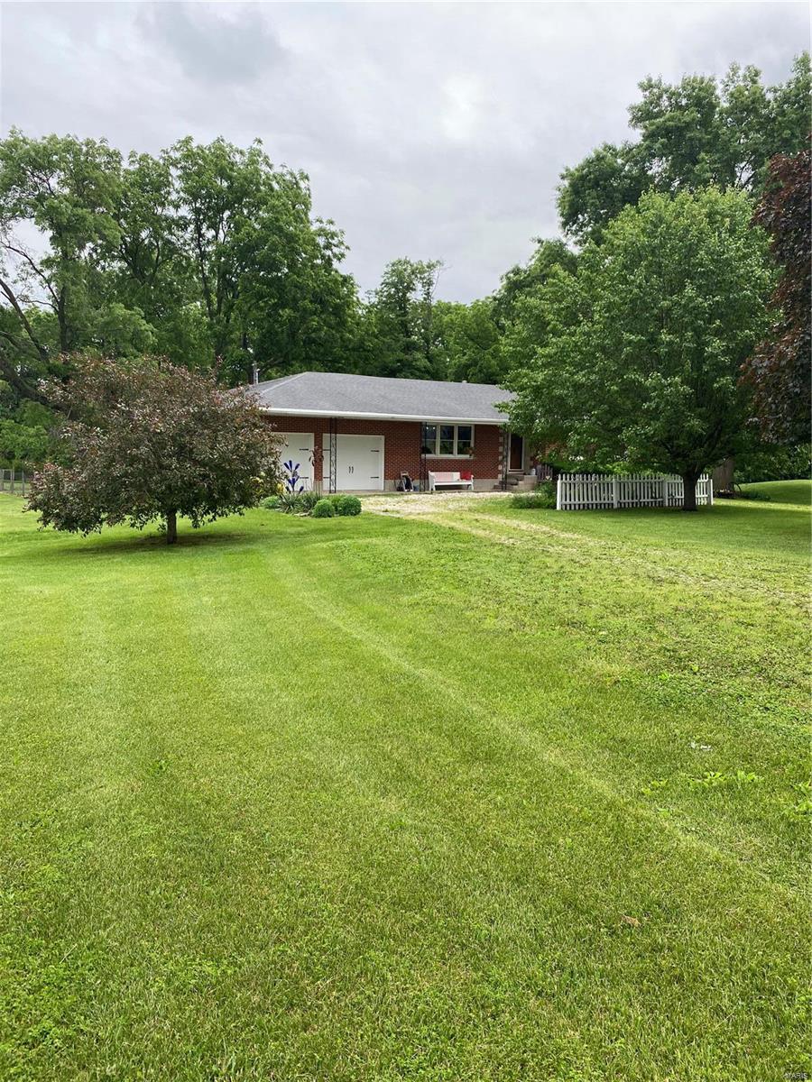 A charming brick ranch sitting on 3 acres right off of black top!!! You can tell this home has been well taken care of. As you arrive you will see the beautiful pond and mature trees. Inside hardwood floors flow throughout the 3 bedroom 1.5 bath home. The kitchen/dining combo has updated electric appliances, with gas hookups available. The main bathroom currently houses the clothes washer and dryer, making the home perfect for single level living. There are additional laundry hookups in the basement. The very clean unfinished basement is currently used as a hobby space and provides an abundance of storage. Off of the back of the home you will find the quaint screened patio looking out to the large fenced backyard, perfect for your morning coffee. The metal outbuilding adds additional garage space for a lawn mower and a shop which features 220 power. The home is located near a gas pipeline serviced by DaCott Gas providing the home low cost natural gas. This is a must see!