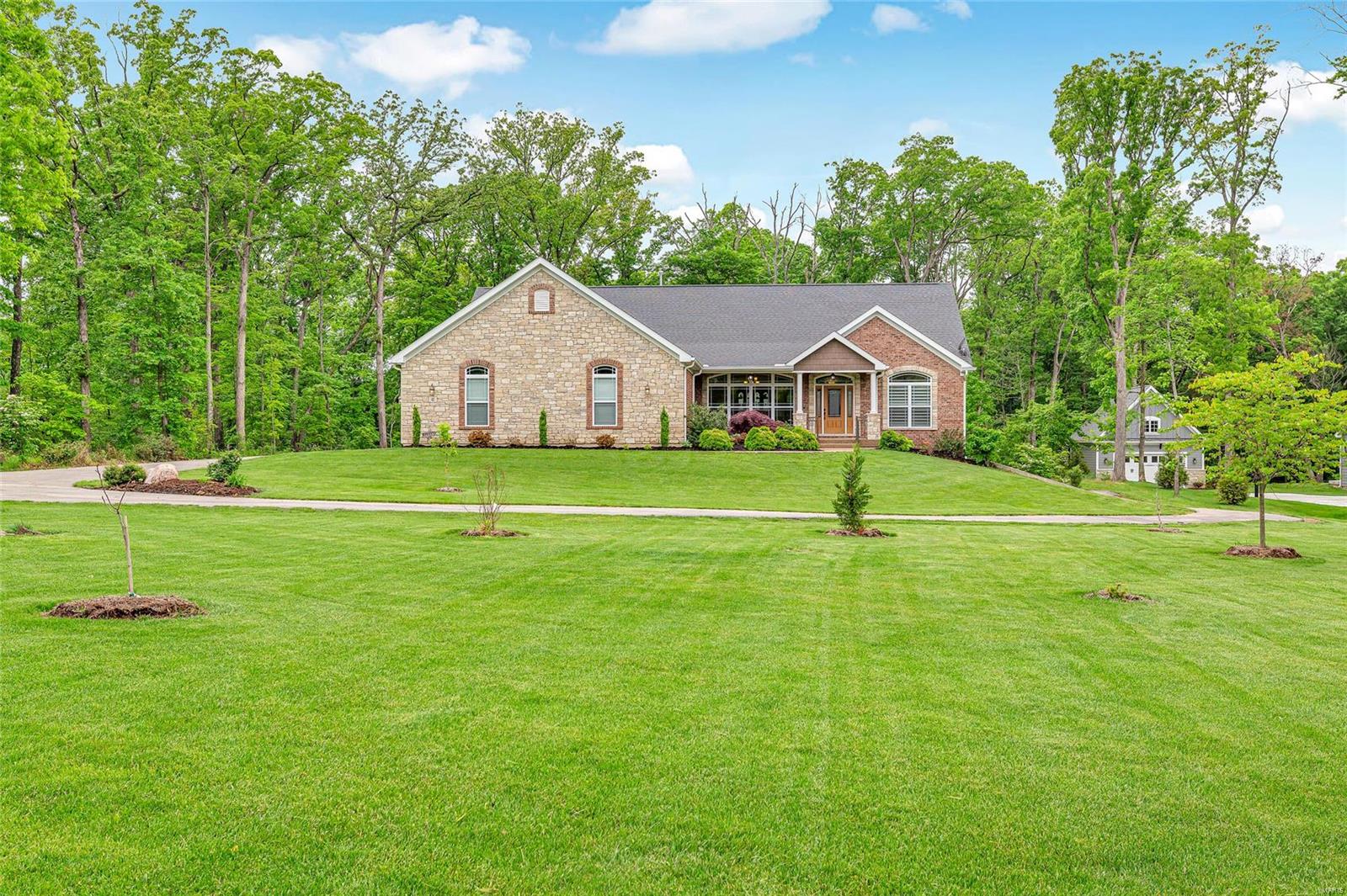 BACK ON MARKET-BUYERS HOME DIDN'T SELL!!! Located at the edge of town in the New Melle area. This beauty has spacious rooms, 11' walls, granite, back splash, butler's pantry, huge center island breakfast bar & hand scraped wood flooring is predominant throughout the main level. The owners suite has his & hers vanities, jet tub, step-in shower with dual heads, custom etched-glass window & large walk in closet that leads to the laundry room with sink, cabinetry & folding table. The walk out lower level features in-law quarters with microwave, refrigerator, large family room, full bath, bedroom, work out room & possible safe room. Lots of unfinished storage or room for additional finish. This park-like setting, stamped patio with stone walls & custom lighting will win you over. Separate patio nestled against the trees is designed for a fire pit. Oversized 3 car garage that is extra deep & has room for a workshop. Francis Howell Schools/Daniel Boone Elementary.