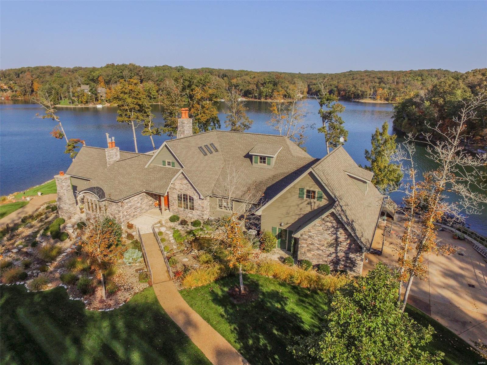 Elegance!! Privacy!! Breathtaking views!! This home has it all!!  Located on premier Lake Alpine, situated on one of the most desirable settings, steps away from the water’s edge is nothing short of brilliance to detail combined with attention to the surroundings.  The expansive windows offer panoramic lake views from almost every room while towering oak trees frame the beauty of the setting in the distance.  Considering entertaining family and guests, concerned about enough space, fear not as the guest accommodations could not be more adequate for large groups or intimate get togethers with close friends.  The custom kitchen would impress anyone, whether amateur or professional. Custom millwork adorns this residence while vaulted ceilings create spaciousness and warmth throughout.  Enjoy the spaciousness of the patio just off a lower level game room including a beverage center steps away from your personal gym and media room. Home being sold turnkey excluding piano & personal items. Additional Rooms: Sun Room
