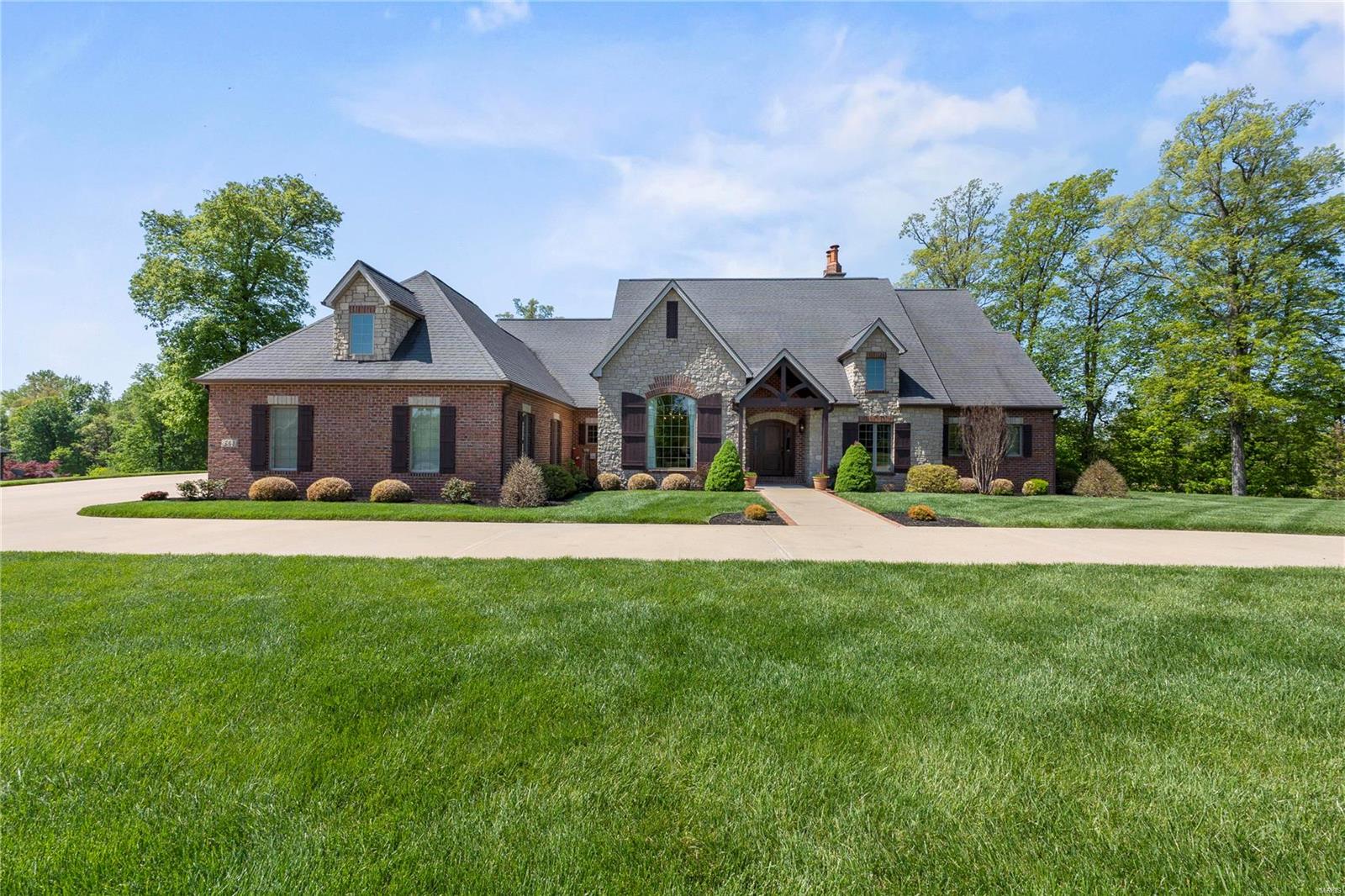 A Remarkable Find....A Wonderful Custom Brick and Stone Ranch home in Windwood Lake Estates with too many amazing features to list!  This home was built with uncompromising quality, impeccable finishes, and has been meticulously maintained by the original owners. Beautiful hardwood floors, not just one but four fireplaces that provide warmth and style, two large living areas the main level with vaulted ceilings and custom built-ins throughout. A kitchen that boasts all the counter and storage space you could ever want with Kitchen Aid custom cabinet appliances, granite countertops and a great walk-in pantry. The main level primary bedroom retreat is so roomy, with a luxurious bathroom that has it all.  You just have to see the incredible lower-level walk-out with so many windows, custom built-ins and two incredible guest suites. The outside living areas are stunning with wrought iron accents, stone built-ins and luscious landscaping is to die for! Come see this beauty!