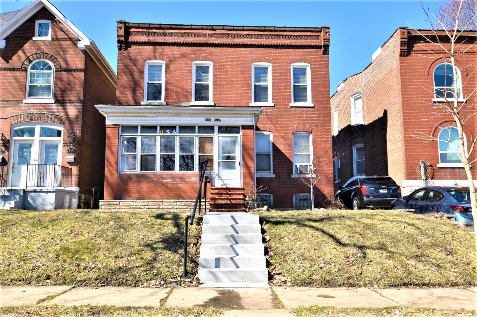 Here is your opportunity to live in a 2 family on The Hill! This full brick, long time family owned property, offers 2 beds/1 bath in each unit, with a screened in shared front porch. The vacant 2nd floor also offers a balcony overlooking a huge yard. Considering the outstanding turn of the century neighborhood homes, this 2 family could become a single for the right person. Or consider a live/work space. Updated zoned electric and gas service, high ceilings, hardwood flooring under carpets, and decorative fireplace in 2nd floor unit. Windows galore, roof approximately 15 years old & new concrete sidewalk around the property.  The fenced lot leads to a garage, with 2 man doors, off alley. It is currently used for storage but could be a creative space. Dual laundry in walk out basement offers more storage, with multiple glass block vented windows. First floor tenant will be vacated prior to closing. First floor unit only available for showing with accepted contract. To be sold As-Is.