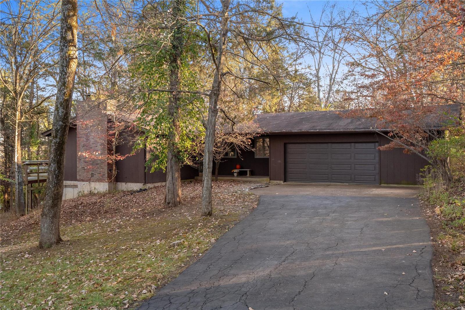 From the moment you drive up to your new home, you will be transported to all the peace & tranquility that surrounds you. Nestled on a wooded 1 acre lot, this cedar home feels like a retreat. The open floor plan draws you into the living and dining rooms, and opens to a large deck. The living room looks out onto the lake making this the perfect spot on a chilly winter night in front of the fireplace. Hardwood floors and large windows are inviting. Built in shelving flank the gas fireplace. There is a master suite with dbl closets, bay seat and attached full bath. Two more bedrms and full bath on the main. The large eat in kitchen has white cabinets, honed black counters, 2 pantries and a custom hand made tile backsplash. The washer and dryer are behind closet doors. Downstairs a huge open floor plan is full of possibility. There is a bedroom, full bath, utility room storage room and cedar closet- And it has lots of windows and full walk out, so you never feel like you're in a basement.