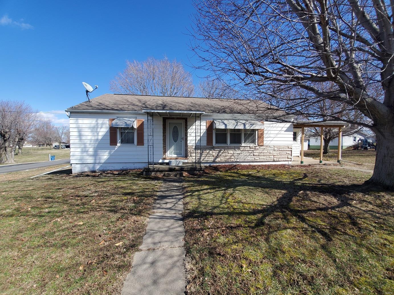 It’s not often that we can say a home has only had 3 owners, but this very well-kept ranch home has, and each has kept it in impeccable condition. You’ll be impressed with the hardwood floors, sunny interior & move-in-ready condition. The spacious living/dining room overlooks the shaded front yard and walks right back to the kitchen, where all appliances convey.  You’ll appreciate the updated sunroom with knotty pine interior and a back door that leads out to the garage & a side front door that opens to the covered front patio.  The main level includes 3 full bedrooms (1 currently used as an office) & an updated bath. Downstairs you’ll find plenty of rec room, the utility room, bathroom & laundry room.  A few more bedrooms could easily be added in the basement.  The detached 2-car garage offers plenty of parking & additional storage.

You’ll enjoy the shaded yard, grape vines & corner lot location here!  This is a quick 15-minute drive to Quincy, IL or 30-minute drive to Keokuk, IA. Additional Rooms: Mud Room