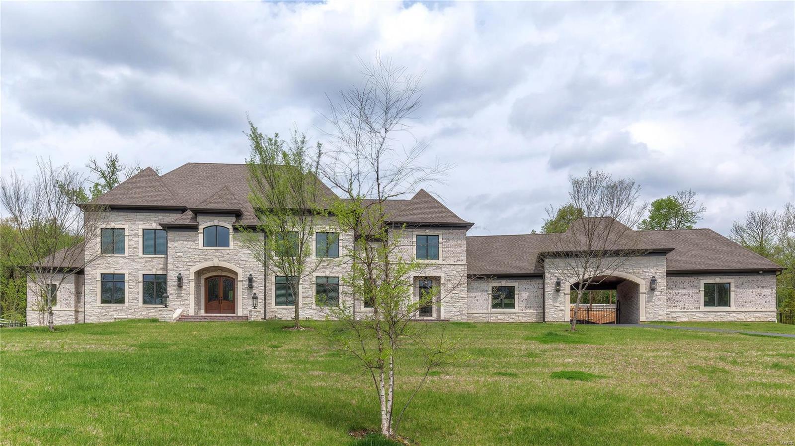 This magnificent European-styled Estate home features over 10,000 sf of living space enhanced by superb craftsmanship & distinctive architectural elements. Expansive 2-sty hardwood foyer highlighted by  dramatic sweeping staircase leads to library-paneled study, beautifully appointed dining room & stunning great room with 12’ box beam ceiling, slate fireplace & wet bar. Exceptionally large kitchen with commercial grade appliances, granite countertops, extensive cabinetry & 10’ x 6’ center island adjoins vaulted breakfast room with bank of windows & hearth room with stone fireplace & atrium doors to screened porch. Coffered master bedroom with dressing area & lavish bath offers a relaxing retreat. Front & rear staircases & elevator access 4 additional bedrooms, 2 with ensuite baths & 2 with Jack n’ Jill bath, & 2nd floor laundry. Walk-out Lower Level includes recreation room, workout room & full bath with sauna. Situated on 2.5 ac grounds with patio, pool, porte cochere & 4-car garage. Additional Rooms: Mud Room