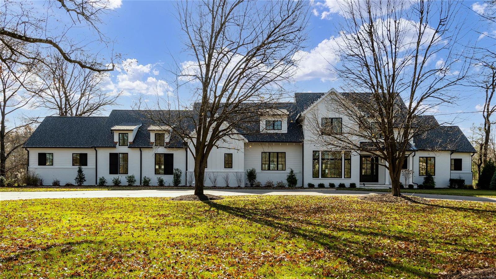 This fabulous 1.5 story Frontenac home is nestled on an acre in the Ladue School district. Brand new 4 bedroom home features a light-filled open floor plan and an impressive array of upgrades including beautiful millwork, hardwood floors throughout, oak beams, designer lighting and 10’ ceilings on the 1st floor. Lovely main floor primary suite with two generous walk-in custom closets, huge primary bath, shiplap paneling, heated Carrara marble floors and free standing tub. The gourmet kitchen has Thermador appliances and Carrara marble countertops. The adjoining hearth room with wood burning fireplace, walk-up bar and 14’ vaulted ceiling leads out to a covered rear porch with views of the private and level backyard. Study, large living room, mud/laundry room and 1/2 bath complete the 1st floor. The 2nd floor comes with 9‘ ceilings, 3 en-suite bedrooms, and a 2nd generously sized laundry room. In addition, the oversized 4 car garage make this modern farmhouse a truly one of a kind! Additional Rooms: Mud Room