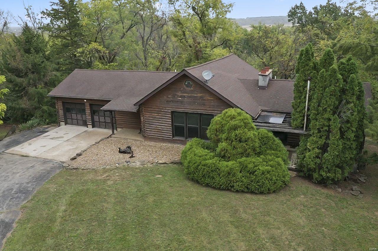 Searching for a carefree lifestyle in a quaint town with built-in privacy? Well look no further than this rustic log home situated on 4.3 acres bordering the Cuivre River & anchored by the park, in the heart of Moscow Mills! You will be romanced by the natural beauty of this unique setting from sunrise to sunset! The welcoming vaulted Great Room, warmed by the woodburning fireplace is sure to impress! Enjoy staying connected with room to sip & chat in the adjoining open kitchen. The main level features a master bedroom suite & sunporch, convenient mudroom, walk-in pantry, laundry & bath between the kitchen & garage. Enjoy the sights & sounds of nature on the 37' deck out back...perfect for morning coffee & dinner under the stars! The open staircase leads to the lower level with flexible living space~ family room with fireplace, 3 bedrooms & 2 full baths. This space lends itself to in-laws quarters or teen hangouts! Walkout to covered patio. Being sold "AS-IS" seller to make no repairs.