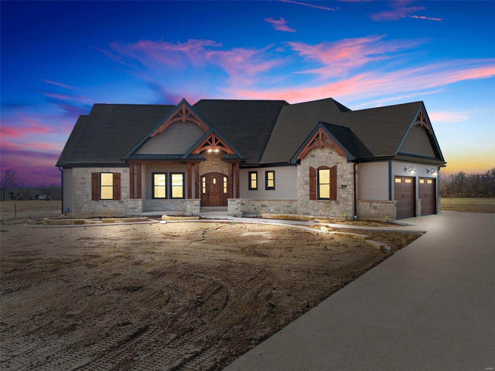 This stunning home very near completion - only odds and ends remain and will be completed soon! Absolutely gorgeous lot with new landscaping, an outdoor kitchen, huge covered patio and beautiful stone fireplace. The yard is screaming for a pool! The home features an oversized 3 car garage and loads of custom stone and cedar on the exterior. Upon entry you will find a large great room, dining area/kitchen that welcomes you immediately. The vaulted ceiling features custom exposed wood trusses and a floor to ceiling stone fireplace with"isotherm" gas firebox. 10 ceilings throughout with a few trays and vaults to add to the dramatic height.  The kitchen features custom cabinetry, a huge center island and GE Monogram appliances. Elegance abounds throughout this split floor plan - 4 beds, 3 12/ baths with a custom finished basement complete with wet bar area. This home is loaded with special features and needs to be seen!