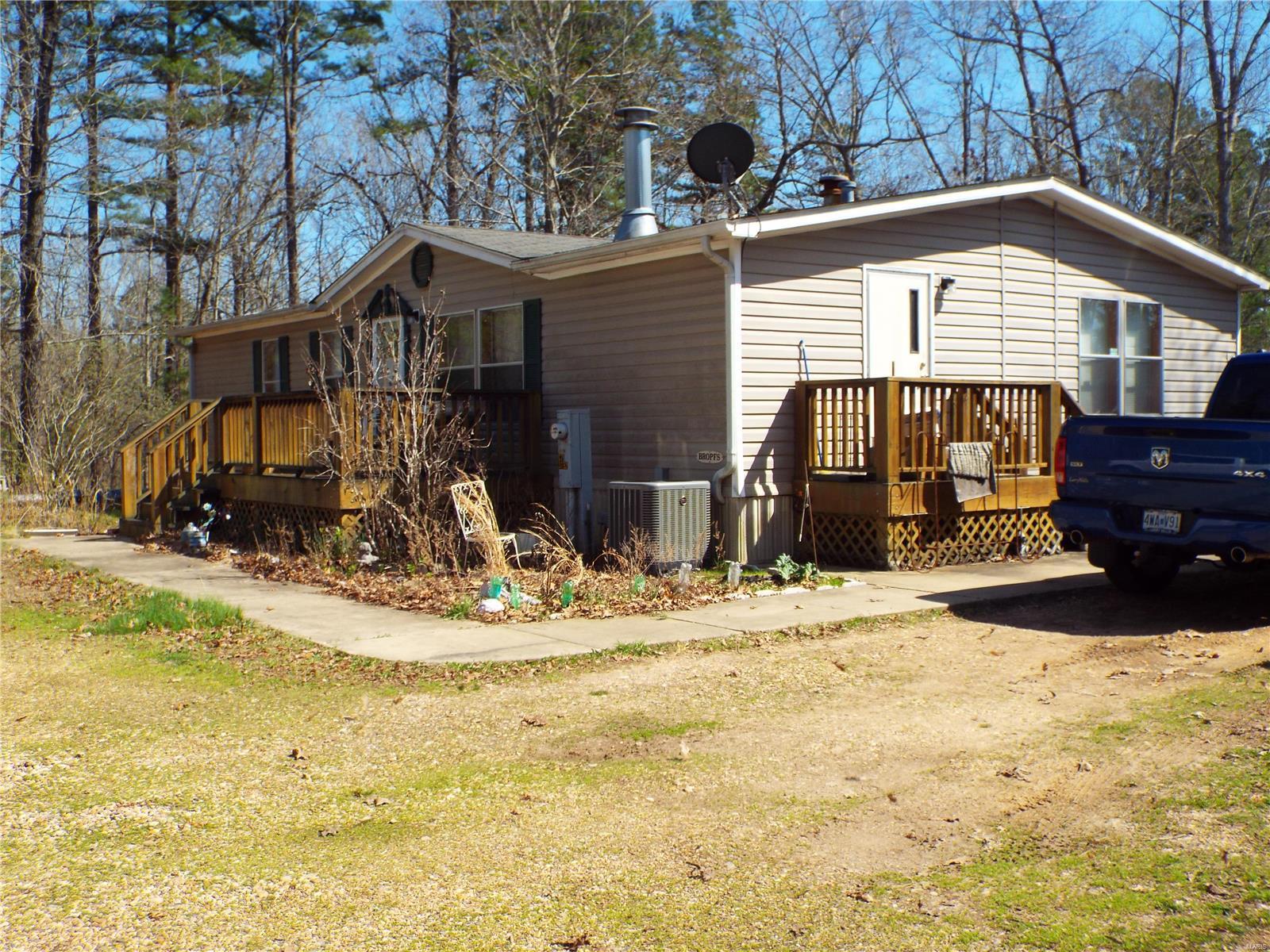 Nice double-wide mobile home and 4 storage buildings sitting on 10 acres of beautiful Ozarks woods. Located 8 miles south of Piedmont on Highway 34, this home offers seclusion and privacy while being only a short 10-minute drive to town. Hunting and fishing enthusiasts will appreciate the opportunity to be close to nature in an area where deer and turkey abound, and Black River is only a short drive down the road. Enjoy a morning cup of coffee out on your back deck while listening to the songs of birds and watching squirrels hop from limb to limb.