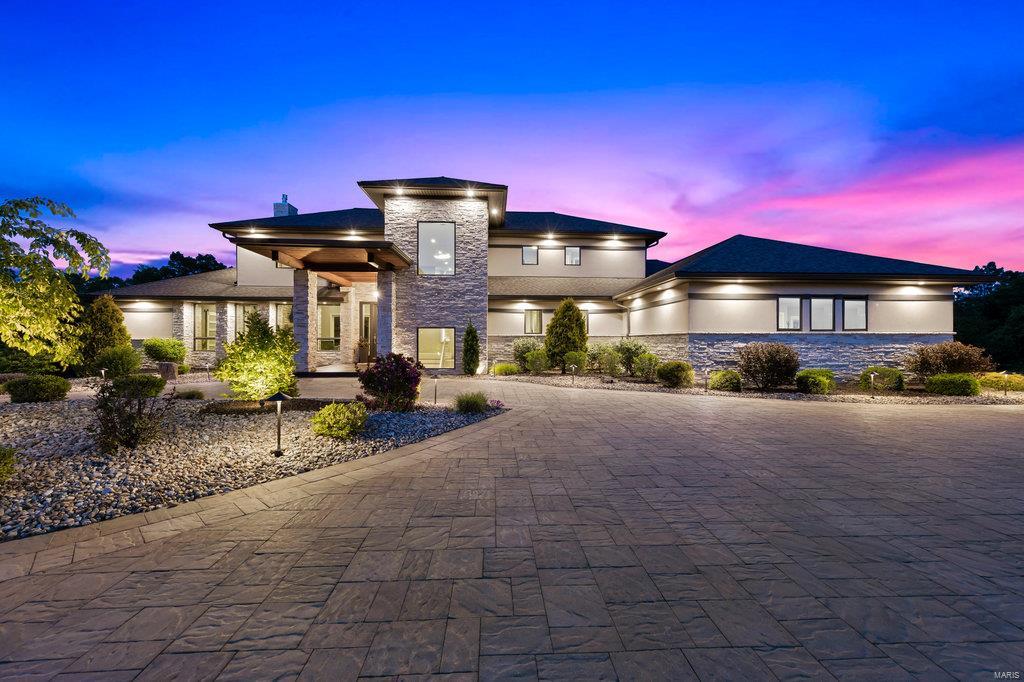 Welcome to 940 Bluff Rd- nestled on nearly 8 acres, your new home offers incredible views of the Mississippi River & the iconic Arch, a stunning sight just 26 miles from your backyard. Welcome to an exclusive gated community boasting only 12 prestigious lots, where 9 homeowners already relish their slice of paradise. Prepare to be mesmerized by the modern elegance of this architectural marvel, boasting a stucco exterior w/ exquisite stone accents. The meticulously manicured landscaping is equipped w/ a lawn irrigation system & magnificent lighting, setting the stage for the grandeur that awaits within. Step inside this crafted home, where no expense was spared in the creation of this masterpiece. With 4600 sqft of luxurious living space, every room offers a haven of comfort & style. Dreaming of expansion? The unfinished W/O basement offers limitless possibilities to tailor this estate to your desire. Your new home isn't just a residence—it's a testament to the art of living lavishly.