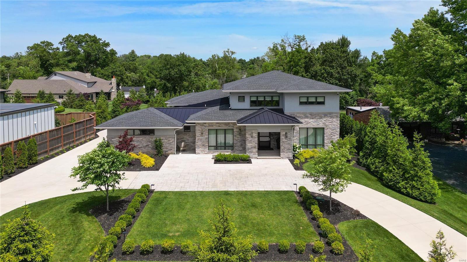 Discover unparalleled luxury in the heart of Ladue. Over 3/4 acre, with plenty of room for a pool. Constructed in 2022 & designed to surpass the highest standards, this accessible residence is equipped with voice command, full-home automation, powered sliding doors, & an elevator to all levels. With over 6,000 SF of living space, including a 1,700 SF finished lower level, the home offers 5 bedrooms & 6 bathrooms. Highlights include 10' ceilings, wide plank wood floors, & a St. Louis Magazine award-winning primary bath. The gourmet kitchen, ceramic-walled living room with safety glass fireplace, organized closets, & luxe outdoor space enhance its appeal. The second level includes 3-bedroom suites & a reception area, while backlit stairs add a unique touch. The expansive lower level features a living area, half bath, full bedroom suite, & storage areas. Additional features: a 3-car garage (room for 5), extra storage, & a front circular drive. A true custom, one-of-a-kind offering.