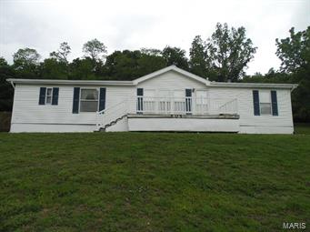 Nice double wide home perched atop a hill awaits its new owner.  This spacious home has 4 BR and 2 BA. and boasts two decks to relax on while listening to the birds sing in the woods just a few feet behind the house.  A huge 40 X 26 detached garage/shed is ideal for a shop.  It is big enough to keep 2 cars and more toys, and has a separate room in the back for parts and more storage.  Look at this before it's too late, priced to sell!