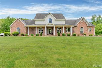 This luxurious 4 bedroom, 4 bath custom home sits on 40.2 private acres including a horseshoe shaped 5-acre pond with it's own cabin & boat dock. Over 5,500 SF, this magnificent residence is graced by beautiful wood floors & opulent features such as decorative columns, 3 fireplaces, & an en-suite bath w/ a soaking tub & separate shower. The master suite spans the entire upper level & is fit for royalty w/ a seating area & walk-in closet. The open layout main living & 22x15 dining room w/ fireplace is made for entertaining. The eat-in kitchen w/ custom built island opens up to the rear deck overlooking a private backyard. The LL houses a family/rec room w/ a wet bar, hearth room w/ wood-burning fireplace & garage/hobby area. The property also has a one story, frame cabin that features: living room, kitchen, bedroom nook & bathroom. The cabin is perfect for hosting guests. It's time to come home & never leave your own paradise!  Priced WAY under Appraisal!