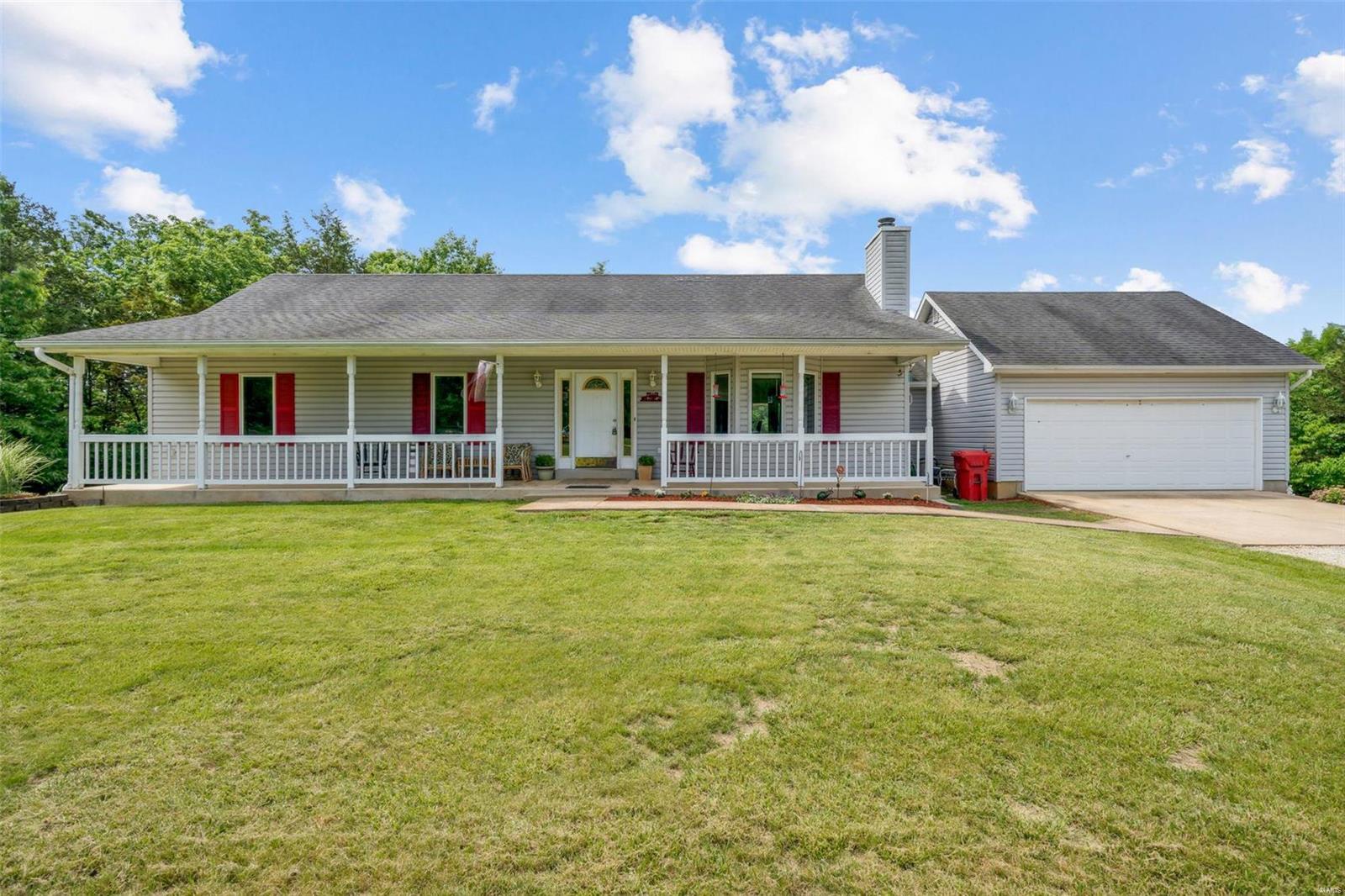 RARE FIND!!! Beautiful setting on 2 plus acres & a corner lot, that's level & wooded for tons of privacy! Come look at this ONE OWNER, very well  maintained home w/ open floor plan, large deck, finished lower level w/wet bar, pool table and more. The front porch is a perfect, peaceful setting for watching deer, turkey & lots of humming birds!  Inside you will love the vaulted ceilings, open floor plan, wood burning fireplace & large kitchen with lots of cabinets & breakfast bar. Off the kitchen/dining area you can walk out onto the large deck overlooking the wooded, private back yard. The oversized two car garage offers plenty of room w/built in vacuum system that allows you to vacuum vehicles in the drive way, & hoses that reach throughout the entire house. Master suite offers walk in closet & large master bath. Lower level is finished w custom built bar, all new bar stools, pool table (which all stay w the house) & workshop area! Call for showing, this wont last long!
