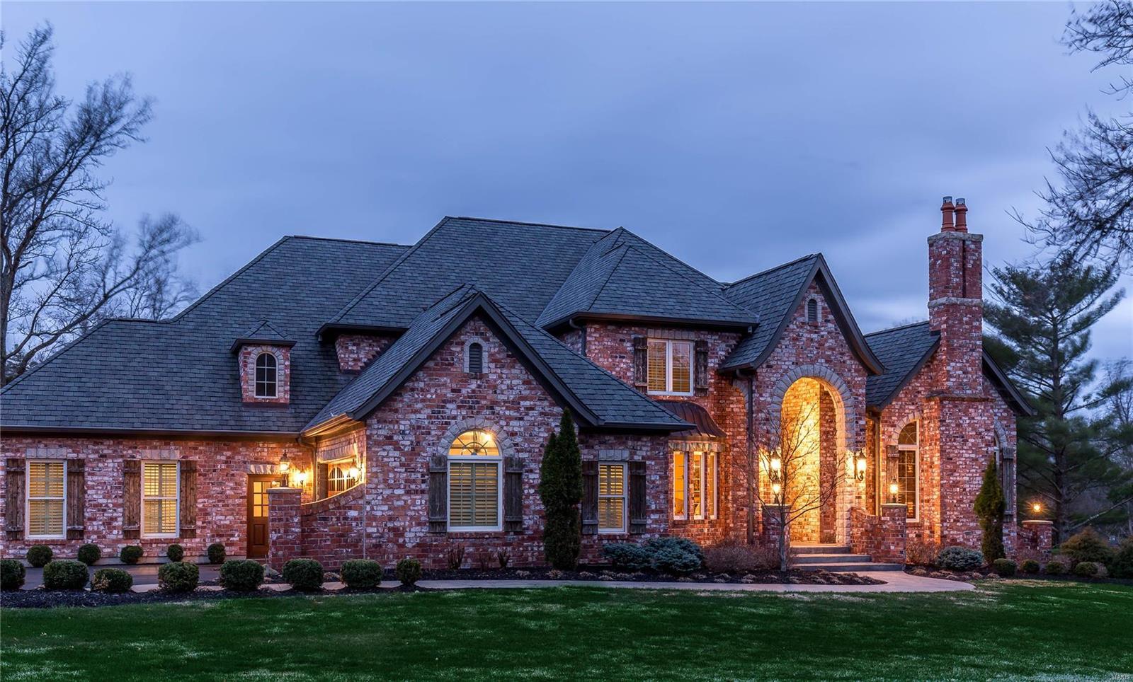 Exceptional English Country Estate, complemented by its soaring ceilings and remarkable millwork offers 6900 total sq. ft. of living space on a lush landscaped 1-acre lot. The main flr features a breathtaking 2-sty foyer w a dramatic sweeping staircase, elegant dining rm, paneled study w/ floor-to-ceiling brick/stone fireplace, great rm with 2-sty bow window and built-in bookcases. Stunning designer kitchen with stainless steel  appliances opens to breakfast rm with French doors leading to the outdoor veranda w a fireplace. Lovely main flr master suite complete with marble bath, steam shower, freestanding tub, & two walk in closets. Second floor features an add'l 3 bedrooms, 1 w/ an ensuite and 2 w/Jack & Jill bath, plus a quaint loft sitting area. Beautifully finished lower level features recreation rm w/ wet bar, game room, workout rm, 5th bedroom, full bath and wine cellar. Stamped concrete patio, 4-car garage & sprinkler system; neighborhood pool & tennis. A must see!