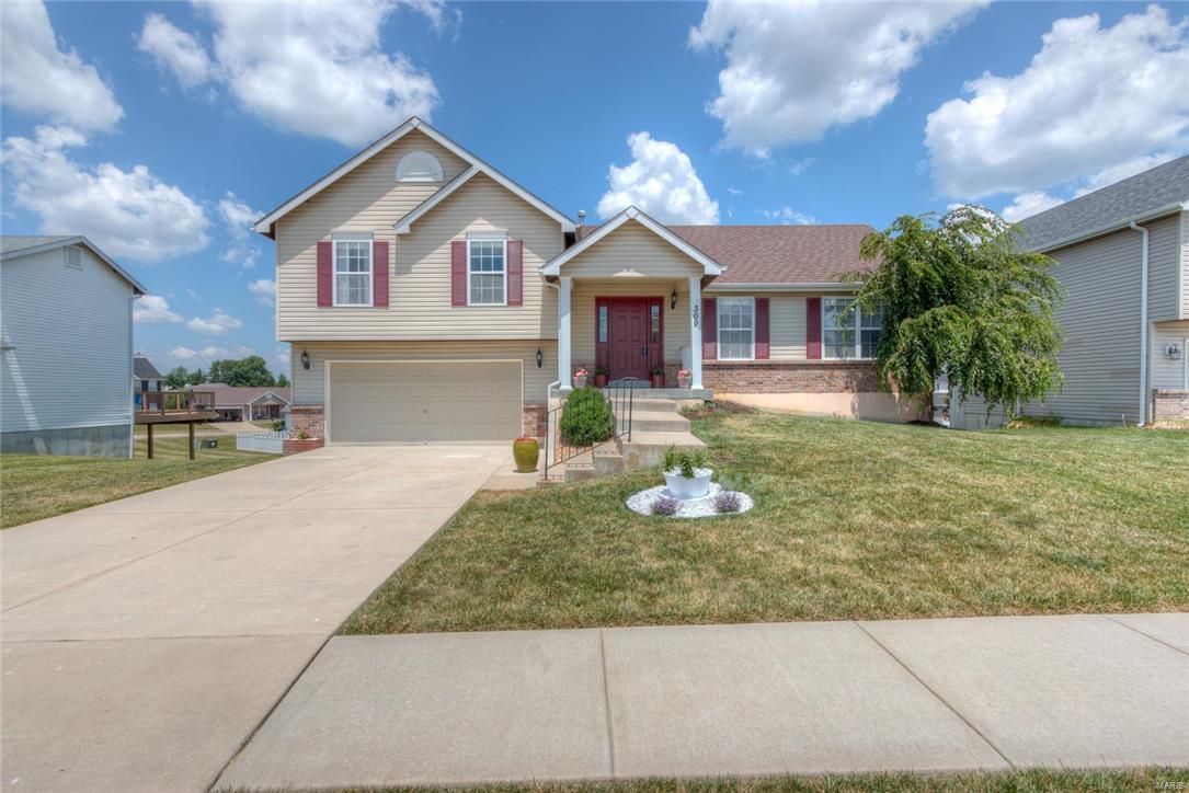 Upon walking into this open concept floor plan home you are immediately drawn to the soaring vaulted ceilings and new wood flooring that make the space feel warm and inviting.  The spacious eat in kitchen has an abundance of cabinetry with large breakfast bar that extends overlooking the large family-room, perfect for entertaining. Upstairs hall bath has been completely redone from top to bottom with new modern vanity, brushed nickel lighting and tile flooring.  Master bath has also been updated and is a spa retreat with new lighting, flooring and tile shower and tub surround that screams luxury which is rare at this price-point.  Step outside onto the generous deck which overlooks the large level backyard. New architectural shingled roof was recently put on this home and solar venting was added to enhance energy efficiency.  This home is just a short walk from the neighborhood pool and is located within the highly desirable Wentzville School district.  This one will not last long!