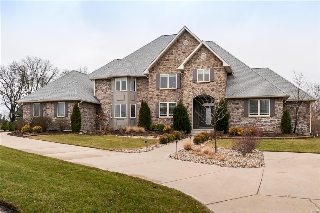 Stunning two-story home with stone front & board & batten style shutters offers an abundance of curb appeal on a beautifully landscaped one acre lot with a resort-like feel. The four-car side-entry garage offers plenty of parking & the screened porch provides versatility for St. Louis weather!

This home with over 5,000 sq. ft., features gourmet eat-in kitchen that boasts Travertine covered floor, granite counters, double stainless steel ovens, Bertazzoni 6 burner stove with grill & pot filler over stove. Dining room offers coffered ceiling & hand-scraped walnut flooring with easy access to butler’s pantry. Beautiful sitting room with welcoming fireplace & convenient bookshelves. Light & bright main floor family room with second fireplace adds to this open floor plan.  The main floor concludes with an elegant master suite with all the extras you would expect. Three spacious bedrooms make up the second floor, along with two full baths & a family room that is great for kids or guests.