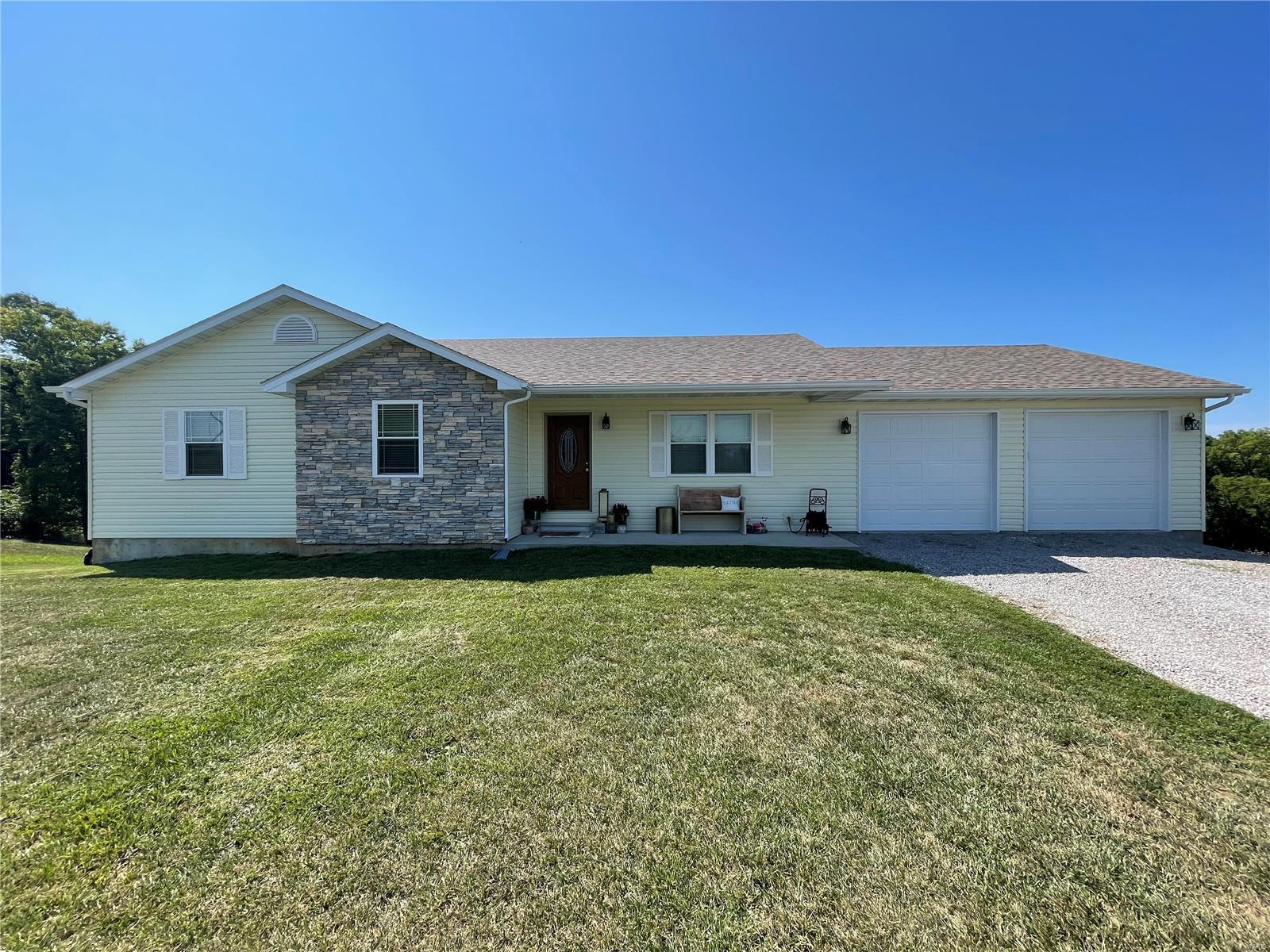 Looking to escape city living, but don't want to be far away from the convenience? This may be just what you're searching for. Located just 1.5 miles outside the city limits sits this charming home. As you enter the home you will find an open concept living room, dining room and kitchen. All spacious areas, very well thought out! The kitchen features custom cherry cabinetry, black stainless steel Frigidaire-gallery appliances including refrigerator, built-in microwave, range/oven. Amana dishwasher. Newly installed countertops and stainless farm style sink. Two guest bedrooms and bath are just down the hall followed by the master bed and bathroom and oversized walk-in closet. All main floor rooms feature newly installed premium laminate flooring! A full unfinished walkout basement underneath with plumbing stubbed in for 4th bathroom. Plenty of room in backyard for kids to play and make their path through the woods to the lake below. Call for your private showing today!