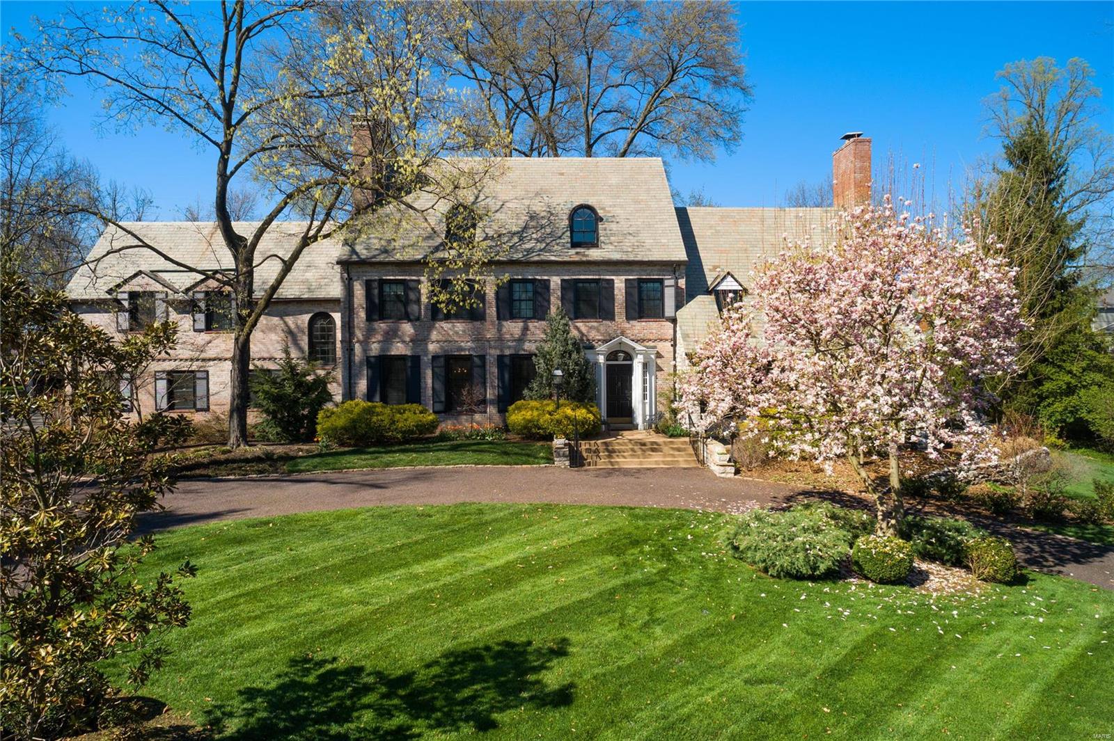 “Hidden by Trees You Will Find My Home” best describes this historic Clayton neighborhood where 10 Carrswold “emerges from the lawn in full sunlight.” The house sits high overlooking the 10+ acre Carrswold Park. A perfect example of a Colonial Revival Maritz & Young home, the whitewashed brick, black shutter & steeply gabled slate roof home was built in 1928. Distinctive architectural details remain: a sunken LR features a fireplace w/ access to a front terrace, a light-filled sunroom w/ abundant built-ins & an oversized DR w/ fireplace to accommodate large gatherings. A gourmet kitchen w/ multiple prep spaces & attached family room for informal entertaining. The 1st floor is complete w/ laundry room, office, bdrm, & master suite overlooking an outdoor pool. 5 bdrms, 3 full ba & oversized home office boasting a built-in desk & shelving complete the 2nd floor. A 3rd floor rumpus room is a bonus space. Close to universities, hospitals, schools, biking/running trails & downtown Clayton. Additional Rooms: Sun Room