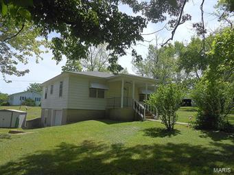 Two bedroom home on large lot in town.  Eat-in kitchen.  Covered front porch.  Enclosed back porch with laundry, could easily make a 3rd bedroom. 1-car tuck under garage w/storage area.  Lovely yard. Additional Rooms: Mud Room