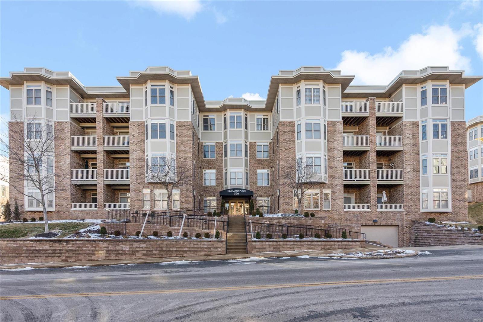 Sought after top floor condominium w/ FANTASTIC light, open floor plan, freshly painted entry foyer, living & dining rooms + kitchen.  Exceptional millwork thru out, spacious living room w/ 2 bay windows, 6-panel doors & coffered ceilings, custom shutters through-out, cherry hardwood floors, great cook's kitchen w/ granite counter tops, 42" cabinets, newer stainless steel appliances, under cabinet lighting, opens to dining area w/ adjoining deck (new composite decking) overlooking the roof tops of University City & Clayton. Very spacious primary suite (large enough for a sitting area) with large walk-in closet + bonus nook which is ideal for a home office or add'l storage. Primary bathroom features double bowl vanity with separate tub & wallk-in shower.  Large laundry room w/ built-in sink & cabinetry.  Common elements have recently been updated, elevator, heated garage w/ 2 parking spaces + storage room.  Walking distance to shops, restaurants, dry cleaners, Starbucks & much more. Location: Upper Level