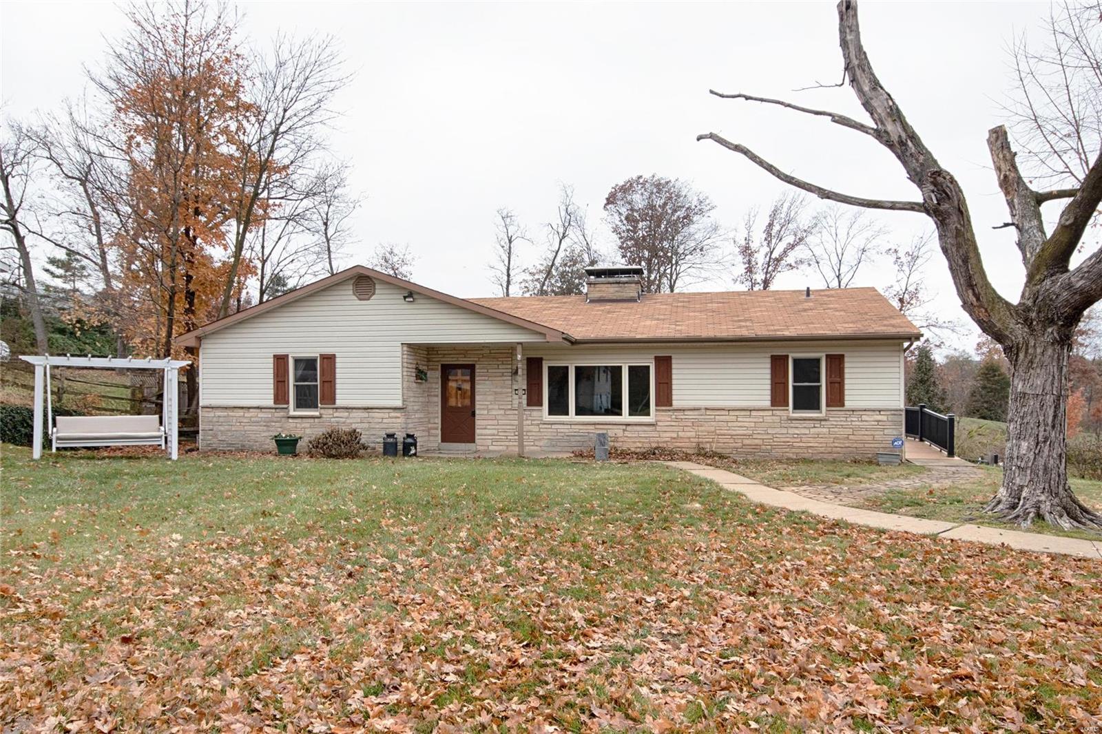 Don't be deceived by the view from the street! You will think this is a small ranch with no garage and a small yard. It is quite the opposite! It is a spacious 4 bedroom, 2.5 bath,  L shaped ranch, with an oversize 2 car garage, plus a 16x26 carport and deck, sitting on .61 acres, with a fenced backyard, and 12x20 storage shed with loft. Enjoy the 2099 sq ft with 2,761 total living area, gorgeous hardwood floors, large picture windows, 2 fireplaces (wood and gas), finished lower level, with 2 walkouts. The Andersen windows (2016) make it extremely quiet. Large kitchen with plenty of cabinets. Pull down stairs with attic storage. Located next to Muirfield and Whitmoor subdivisions, it is priced considerable less, with no subdivision fees, and the price takes into consideration the street traffic and adjacent gravel driveway. Francis Howell school district, near the new Veterans Tribute 100+ acre park, Kisker Library, the Katy Trail, and shopping.