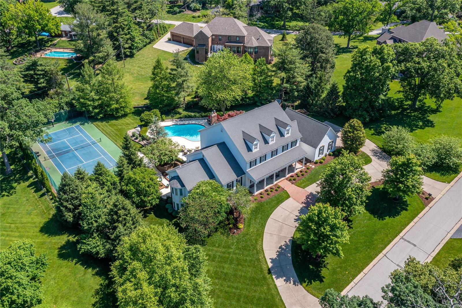 Picture perfect Southern Colonial in prestigious Williamsburg Estates. Impressive hardwood foyer leads to stunning 2-sty rotunda with domed ceiling & gallery landing, elegant living & dining rooms, spacious family room with wet bar & floor-to-ceiling stone fireplace & paneled study with custom built-ins.  Designer kitchen with quartz countertops, 42” cherry cabinetry, commercial grade appliances & butterfly center island adjoins light-filled breakfast room with built-in breakfront. Coffered master bedroom suite radiates warmth with a marble fireplace, His & Hers closets (1 with laundry) & vaulted bath with shower spa & jetted tub. Dramatic floating staircase accesses 3 additional ensuite bedrooms, loft sitting area & 2nd laundry. Walk-out Lower Level includes recreation room with gathering bar, game room & family room with 3rd fireplace plus workout room, wine room & pool bath. French doors open to outdoor living area with hot tub, sport court & pool surrounded by landscaped gardens. Additional Rooms: Wine Cellar