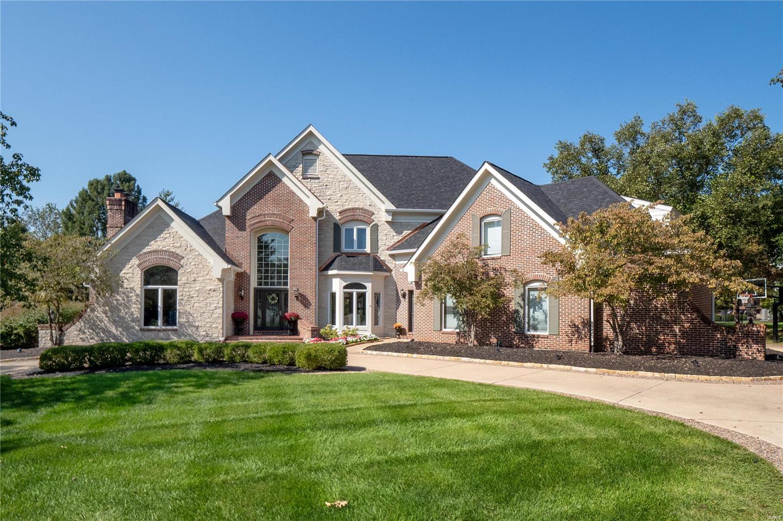 Luxury living awaits in this custom 1.5-story home with over 7,800 sqft, nestled on a quiet cul-de-sac with a private, tree-lined backyard and an inviting in-ground pool. The grand entry opens to formal spaces and an executive office with a fireplace. Perfect for entertaining, the home features a recently updated gourmet kitchen with Thermador appliances, a huge center island, and a vaulted hearth room. The great room offers built-ins, a walk-behind wet bar, and large windows with beautiful views. The main-level primary suite has French doors to a private deck and a spa-like bath with dual vanities, a walk-in shower, and two closets. The finished walk-out lower level includes a family room, wet bar, gaming area, workshop and more. Additional features include a newer roof, 3-car garage, main-floor laundry, deck, and circle driveway.