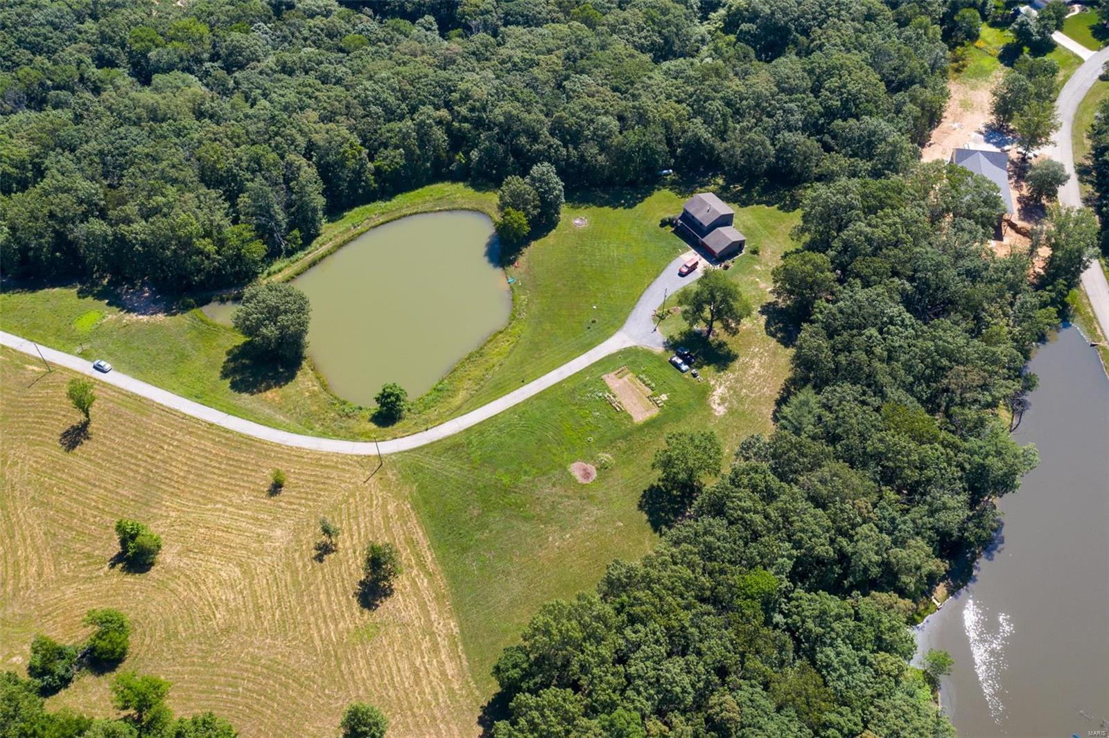 12+ ac setting w/ private lake! Incredible 2 story has all you need & want. Large covered front porch greets you as space to enjoy the view of nature. Great floor plan starts in the foyer & opens into the living room flanked with windows all around & hardwood flooring, doors off of dining space lead to your back deck with pocket screen doors, kitchen is surrounded with custom made Amish cabinets, back splash and granite counter tops. Center island offers extra seating and gas cooktop, spice rack & more. Huge Pantry & Large laundry room is conveniently located off of your oversized 2 car garage. Second floor offers 3 large bedrooms, built in shelving, ceiling fans in every room & updated bathroom. Large master suite offers walk in closet & full bath with shower & large vanity w/ space for all of your extras! Walk out basement is ready for you to finish to suit your needs w/rough in for future bath & egress window for future bedroom. Wet weather creek & ATV/walking trails!