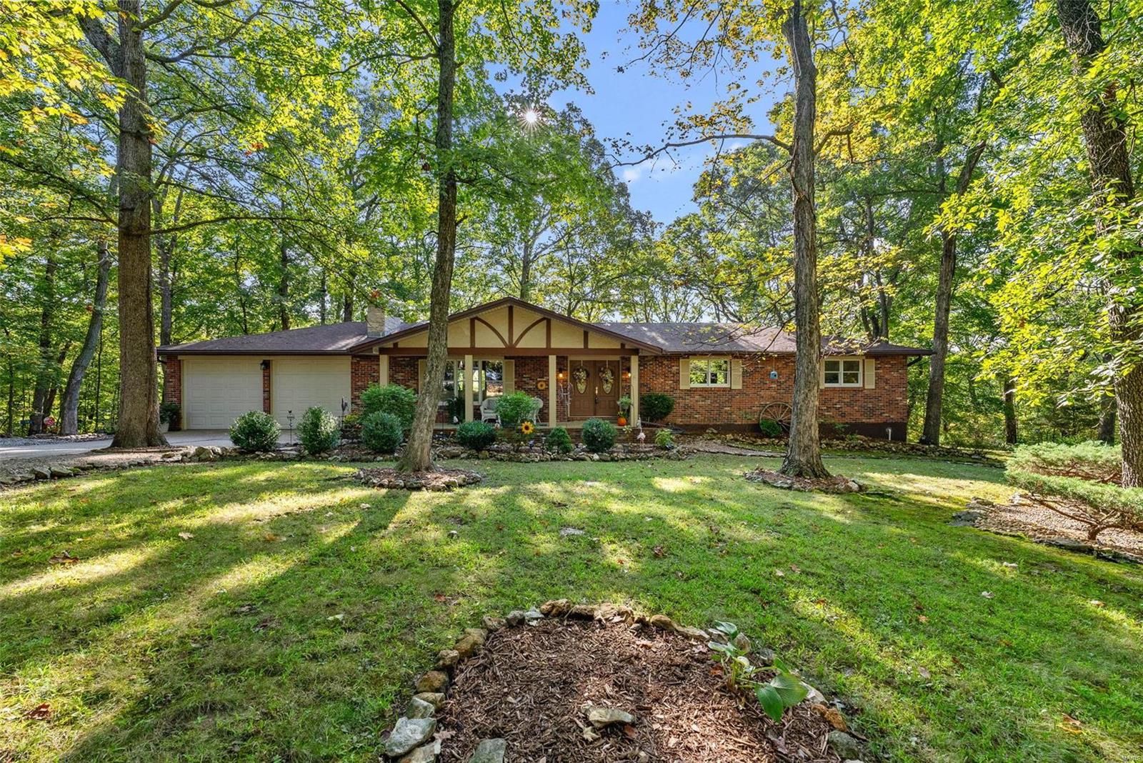 This peaceful hideaway sits at the end of a private street on over 3 acres of woods, & the backyard views are outstanding! Enjoy the changing seasons from the updated deck or the patio. Recent updates include the roof, both bathrooms & a BRAND NEW septic system. Tall vaulted ceilings w/wood beams & skylights & a lovely stone fireplace make the family room a welcoming place to gather. Immaculate kitchen w/stainless steel appliances, pantry & breakfast room. Access the deck from the kitchen or the primary suite w/walk-in closet & private bath. Walk-out lower level w/fireplace, roughed-in bath & some stud/drywall completed. Deep garage w/workbench area. Easy access to I-64 & close to Broemmelsiek Park's hiking/equestrian trails, fishing/kayaking lakes, dog park, astronomy viewing & more. Located at the doorstep of St Charles County Wine Country & nearby small town conveniences in New Melle. Francis Howell Schools. The perfect mix of privacy & convenience! Such a lovely home! See it today!