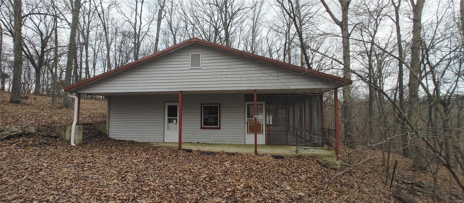Here's a great opportunity to scoop up a weekend getaway spot full of swimming, fishing and outdoor recreation at a bargain price. This little 2 bedroom 1 Bath cabin is nestled on a wooded hilltop lot in a gated community only minutes from Jackson, MO.  The maintenance free exterior is comprised of vinyl siding and a metal roof. Just off from the kitchen and living room is a sliding patio door leading out to a large screened porch that's sure to be a favorite spot for meals and conversation while looking out over the wooded hillside. A like-new HVAC system will keep the interior at just the perfect temperature for any season. This is one of those instances where a little "sweat equity" could yield a nice ROI not only in terms of dollars... but years of memories waiting to be made! SpecialListingConditions: Foreclosure