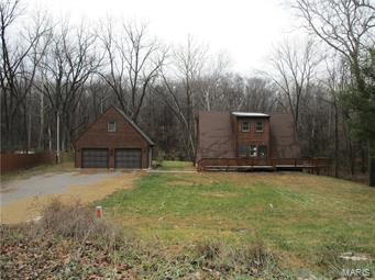 If you are looking for country living close to town, this property will appeal to you! Property could be used as single family home with detached apartment above garage or could be a multi family unit with 3 separate living areas. Main level has office or small bedroom, half bathroom, living room with many windows and fireplace, kitchen with attached laundry area, and dining room that walks out to one of the decks. Upstairs has one bedroom and loft area. Basement has kitchenette, family room, full bathroom, laundry area, and additional sleeping room. Two car detached garage with one bedroom apartment above the garage. The house is situated on private, wooded lot and has two decks to enjoy the country living!  Use caution when showing property-no utilities turned on. Home is being sold as is. Owner occupant offers for the first 15 days of the listing. 10 DAYS FIRST LOOK PERIOD. SpecialListingConditions: Foreclosure