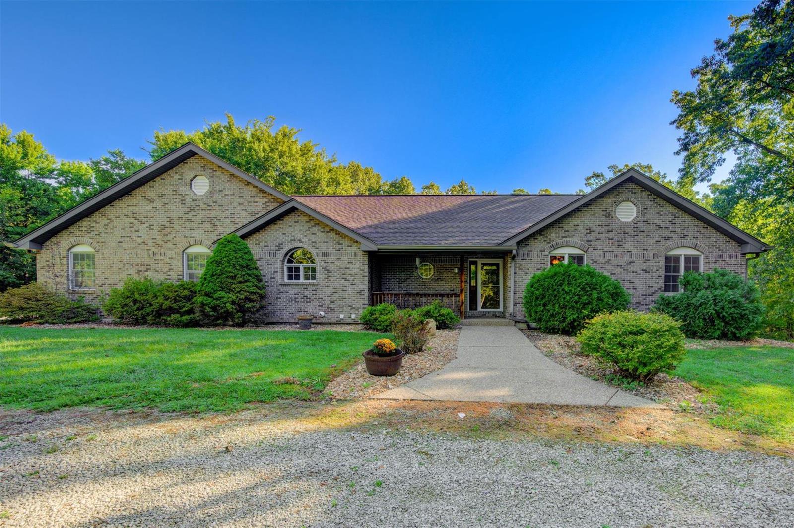 Flat yard with 4.25 acres (no restrictions) with woods behind.  All brick.  36 x 15 ft sunroom/porch with 22 windows, cathedral wood ceiling and a 2nd gas fireplace.  Lower level game room, 36 x 15 with black industrial grid ceiling.  (Porches adds over1000 sq ft of living area)  Lower level adjacent Family Room 36 x 34 with wet bar, perfectly set for entertaining.  Business suitable with 24 x 8 covered walkway behind garage to private office entrance.  Extras abound including DBL WO LL, plant shelves, wood trim package, oversized 2 car side entry garage with 8 ft doors, palladium windows, jetted tub, clear septic and lifetime roof warranty. 
4300 square feet of total living area which includes over 1,000 sq ft with 2 enclosed porches.  Tax record is incorrect.  Actual acreage is 4.25 acres. Additional Rooms: Sun Room