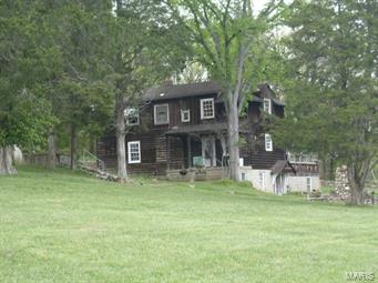 A Rustic Home with 3 bedrooms and 2 baths. The living room is sunken, Kitchen eat-in .  Full bath on first floor. Glass in porch.
Second floor walk up the curve wood steps to two bedrooms and one full bath.  Large closets in house.  Most wood  floors.   Basement has a wood bar that could be made into rec. room  .  Another room not finished with toilet and sink hook-up.  Look out the house to spring feed lake for you John boat.  Has a detached one car oversize garage.  Other building on property.  Owner will do no inspection , or repairs.  But Buyer may do any inspection at his cost and only information for him. Electric is off.  The property needs total rehab to be done to it.  14.79 acres. Great for horses and  deer and turkey on land at times. Agent is related to seller.