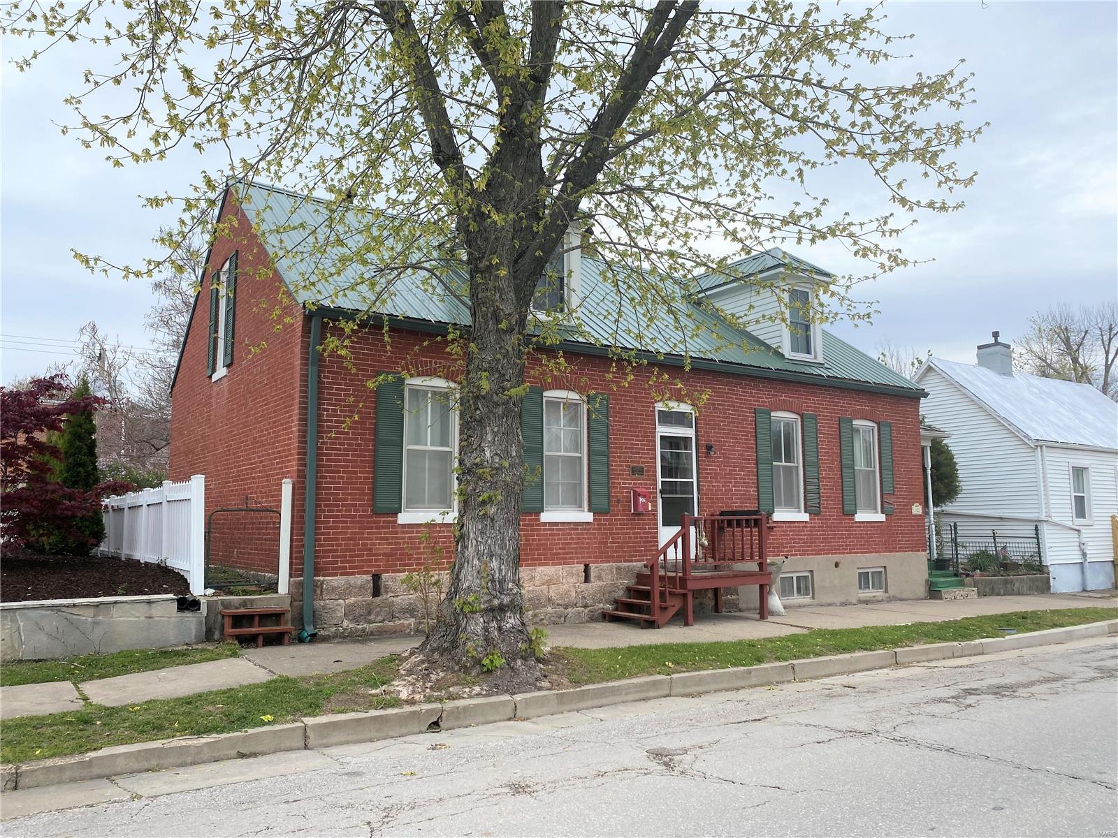 Charming Historic Home for sale in Hermann!! Potential income producing in commercial district just 1 block from downtown! The main home is a 1840's brick house with one small bedroom on main level and 2 larger bedrooms on upper level. Main floor also has a living room with fireplace and built in shelving for TV/books/decor. Also on main level is the dining room and adorable kitchen. Step out the back door of the kitchen down into a sweet little inclosed back porch area, or walk farther out to a covered patio. The backyard is partially fenced and decorated with a variety of plants and seating areas. In addition to the main house you'll find a second cottage that can be used as a guestshouse, office, a long term rental, and many other options. This cottage has a kitchen, living room, full bath on main level and bedroom upstairs. Behind the smaller cottage is a detached garage that offers a lot of space for parking and storage. Property is on the Historic Registry. Call for a showing! Additional Rooms: Mud Room, Sun Room