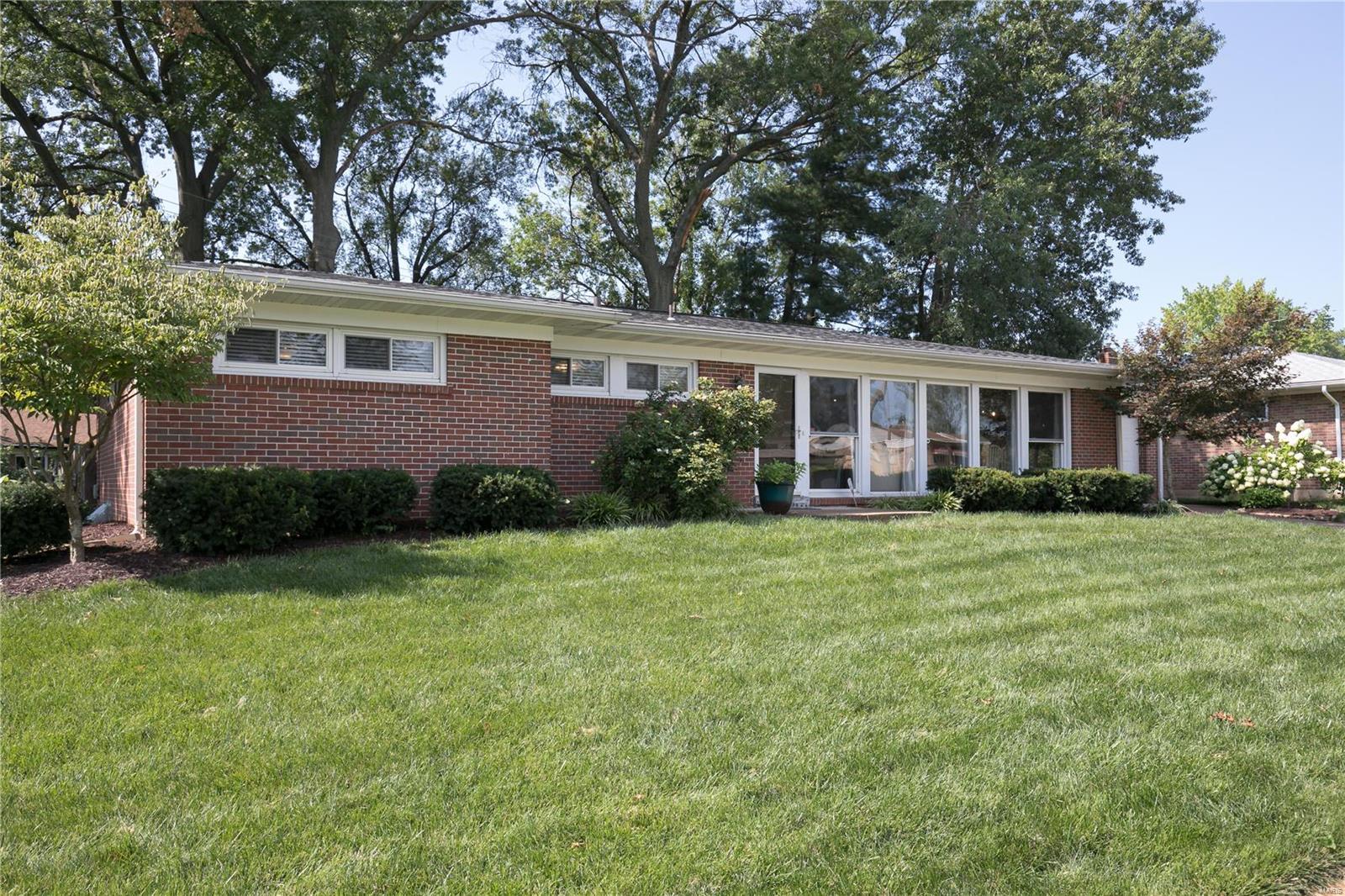 Beautifully maintained and tastefully decorated, this brick ranch is situated on a quiet street with plenty of surrounding green space. Tall floor-to-ceiling windows highlight the open floorplan and create a bright, light interior.  The large updated kitchen features custom cabinetry, stacked stone backsplash, and granite countertops.  An adjoining family room with a wood-burning fireplace completes the open floorplan which is perfect for entertaining family and friends.  The spacious master bedroom includes an updated en suite bathroom.  Two additional bedrooms and a second updated bathroom complete this level.  The lower level includes a large recreation/TV room, a den, laundry room, and ample storage space. An attached one-car garage and a large level backyard with a patio complete the picture. Move-in condition