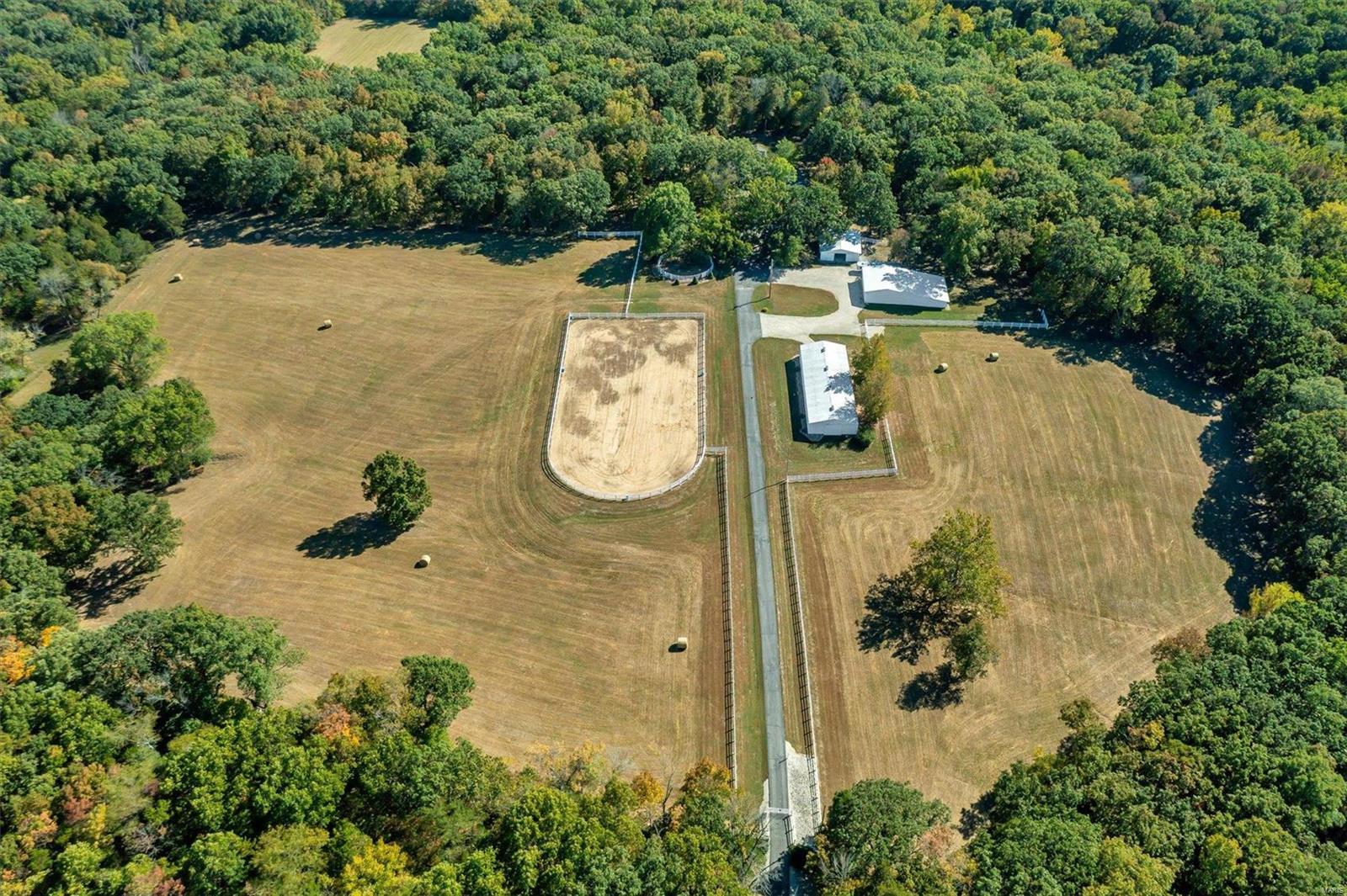 Situated on 135 gently rolling acres & nestled in a 20-acre gated clearing you will find a horse lovers paradise! Full brick, 3 bed, 3.5 bath custom home w/ +- 4500 sq feet of living space & ALL the extra considerations you'd hope to see in a home of this caliber. Structural features include custom brick & stone exterior, 12in thick foundation, 2x6 walls, cellulose insulation, 30year roof w/decorative vinyl cupula, 6inch gutters, insulated water lines w/hot & cold outside spigots, Hurd casement windows & more. Interior features include a Carrera marble entry, large kitchen w/center island, antique white oak cabinets w/leaded glass fronts, a separate dining area, vaulted great room w/stone floor to ceiling fireplace, large master bedroom, double walk-out finished lower-level w/9 ft pour, brick fireplace & tons of storage. The property features excellent hunting, 3 barns totaling 18 stalls, a breeder's lab, indoor training area & outdoor 115x250 outdoor arena, a machine shed & lien-to.