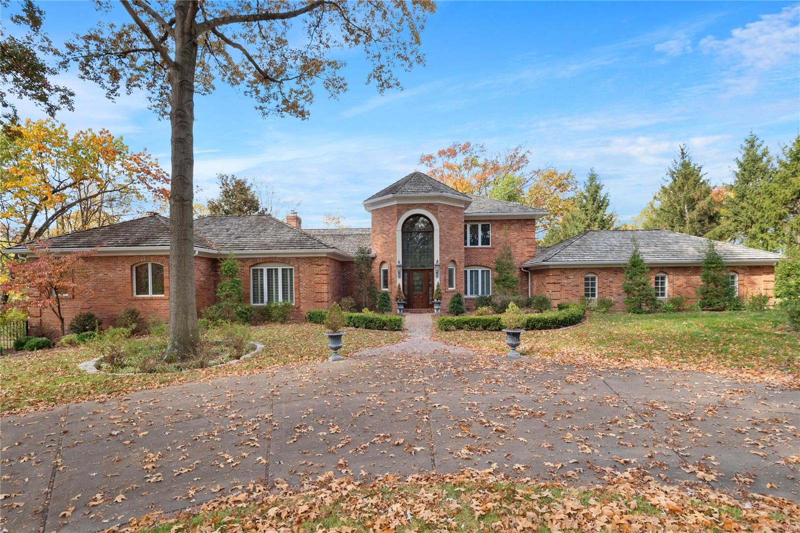 Privacy, elegance, and comfort abound in this picturesque estate on 1.39 mature-landscaped acres in Town & Country. A dramatic foyer with a curved staircase leads to refined and spacious formal living areas with a vaulted ceiling and a private office. The generous main floor primary suite features a large walk-in and his-and-hers bathrooms with a shared shower. The main floor also includes a delightfully family-friendly space with a large kitchen, dining area, and family room. Upstairs are three bedrooms, all en-suite. The partially finished basement is huge and features a half bath along with incredible storage space. Additional amenities include an attached three car garage, newly restored pool, and a detached building with a one-plus car garage and pool house.
