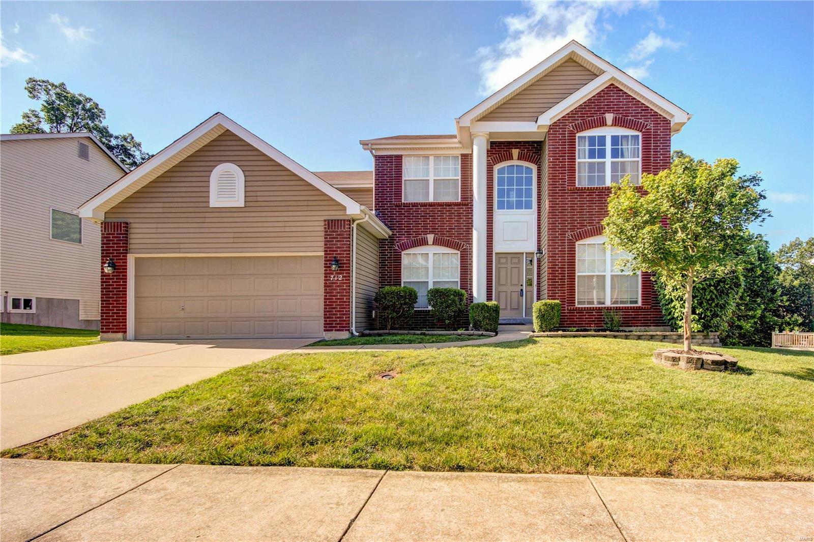 New price! Motivated seller! Welcome to this stunning two-story in Ballwin! A brick front and stately column make for an inviting exterior. Enter to the two-story foyer with the living room to the right and dining room to the left. You'll love the gleaming hardwoods, updated carpet (2017) and 9' ceilings throughout the space! Gather in the bright family room that features a gas fireplace. The kitchen boasts 42" cabinets, stainless steel appliances, and a butler's pantry. A laundry room and half bathroom complete the main floor. Upstairs, double doors lead to the master suite with a large closet, corner tub and separate shower, dual sinks and vanity. Three more spacious bedrooms and a full bath round out the space. The basement is ready for your finishing touches! The deck overlooks the fenced yard and woods beyond. Enjoy peace of mind with a new roof in 2017. On a quiet cul-de-sac, moments from schools, parks, and restaurants and shopping, this home is just waiting for its new owners!