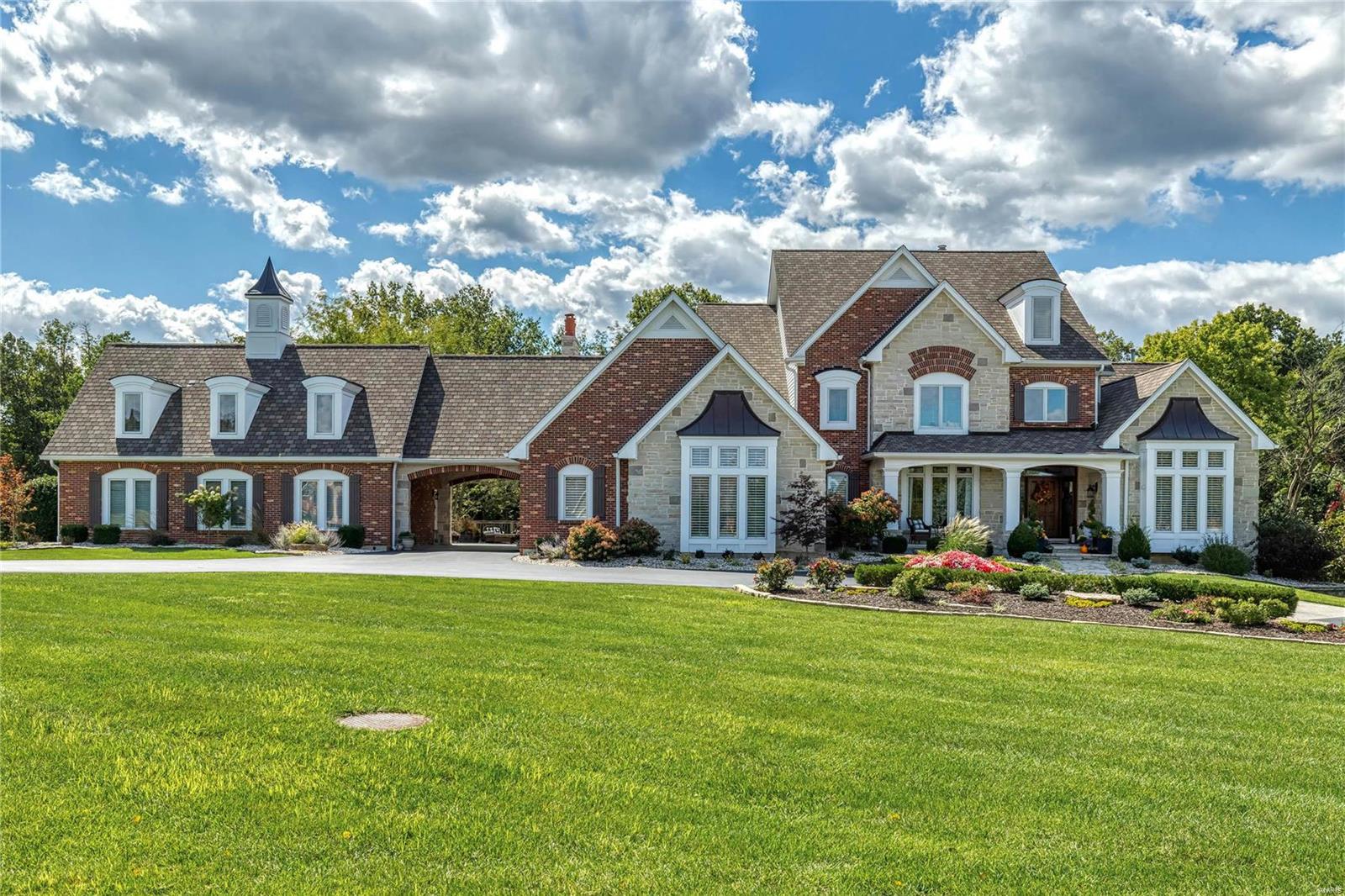 Beautifully designed 9000 sf Estate home on wooded 3-ac grounds. Impressive 2-sty foyer leads to elegant dining room & stunning great room with architectural pillars, wet bar, marble fireplace flanked by built-in bookcases & expansive windows with private wooded views. Designer kitchen with 42” white cabinetry, quartz countertops, commercial grade appliances, 10’ center island & butler’s pantry adjoins light-filled breakfast room with breakfront & hearth room with stone fireplace. Coffered primary bedroom suite with marble bath & adjacent study offers an appealing retreat. Sports enthusiasts will love the golf room with wet bar & cart storage. Front & rear staircases access 3 additional bedrooms, 1 with ensuite bath & 2 with Jack n’ Jill bath. Lower Level includes recreation room with wet bar, billiards room, media room, game room & 1 ½ baths. Atrium doors open to outdoor living area with deck, covered patio & fire pit plus hot tub & resort style pool surrounded by landscaped gardens.