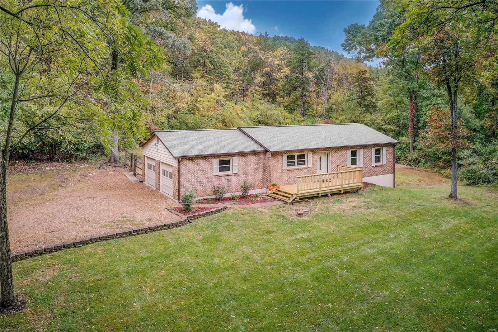 Brick Front Ranch w/ NEW PORCH on tree-lined, level, a 1.5-acre lot in Hoene Springs of Eureka! Open floor plan offers a Family Room and 3 Bedrooms with wood laminate floors and newer ceiling fans. The Kitchen and Breakfast Room are tiled w/ stainless appliances and conveniently located through french doors to the deck allowing you to enjoy outdoor dining surrounded by nature and privacy! The lower level side walk-out offers 2nd Full Bath and is awaiting for your finishes. Laundry is in the basement. Oversized side entry 2 car garage is a plus. There is already a cleared a level spot for a pool! Just a short walk to the neighborhood park! One year home warranty is included and Charter high-speed internet is available.