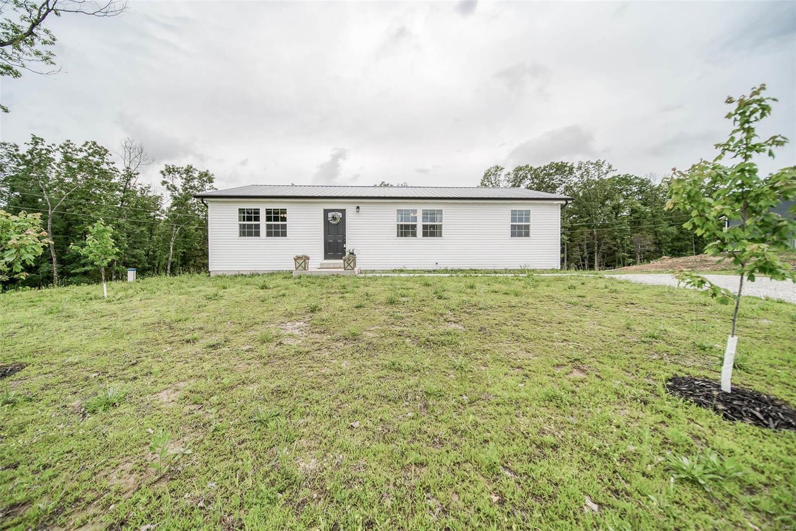 Newly constructed home, built last year on approx 0.5 acre lot...just minutes from I-44 & a short drive to Rolla/St Robert. This home is located on a quiet, dead end street. Enjoy the large back deck that overlooks the woods. Welcoming you inside is beautiful laminate flooring that spans throughout the main level. The living room is embellished w/ a shiplap accent wall & cozy fireplace. The living room flows into the dining area & kitchen. The kitchen is accented w/ a breakfast bar & stainless steel appliances. This home has a split bedroom floorplan. The master bedroom has a master bath w/ double sinks & a large walk in closet. There are two additional guest bedrooms and another full bathroom. Laundry hookups are on both the main level and in the unfinished basement. The unfinished basement could easily be finished out for more livable space or is perfect for your additional storage needs. Lower level also has a tuck under John Deere garage. Schedule your private showing today!