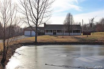 Your place in the country awaits you just a minute's drive off I-55. This peaceful setting with its captivating views sits on 3.84 acres, with a private lake & above-ground swimming pool. There is plenty of room for living & for storage, with more than 2,000 finished square feet on the main level alone. The home offers 3 bedrooms and 3 baths, & a finished walkout basement that can be used as a separate apartment with bonus room, kitchenette & laundry hookups. The master bedroom suite offers jacuzzi tub with separate shower, & two closets - one of them a walk-in. The breezeway has been converted into a great office or sitting room & is heated & cooled. Updates include a 4-year-old roof, & newer bathrooms, bedroom floors & tile, a newer hot water heater & paint. A brand new radon mitigation system has also been installed & provides peace of mind. The property has recently been through thorough inspections & title work, putting you further along the process to your new home