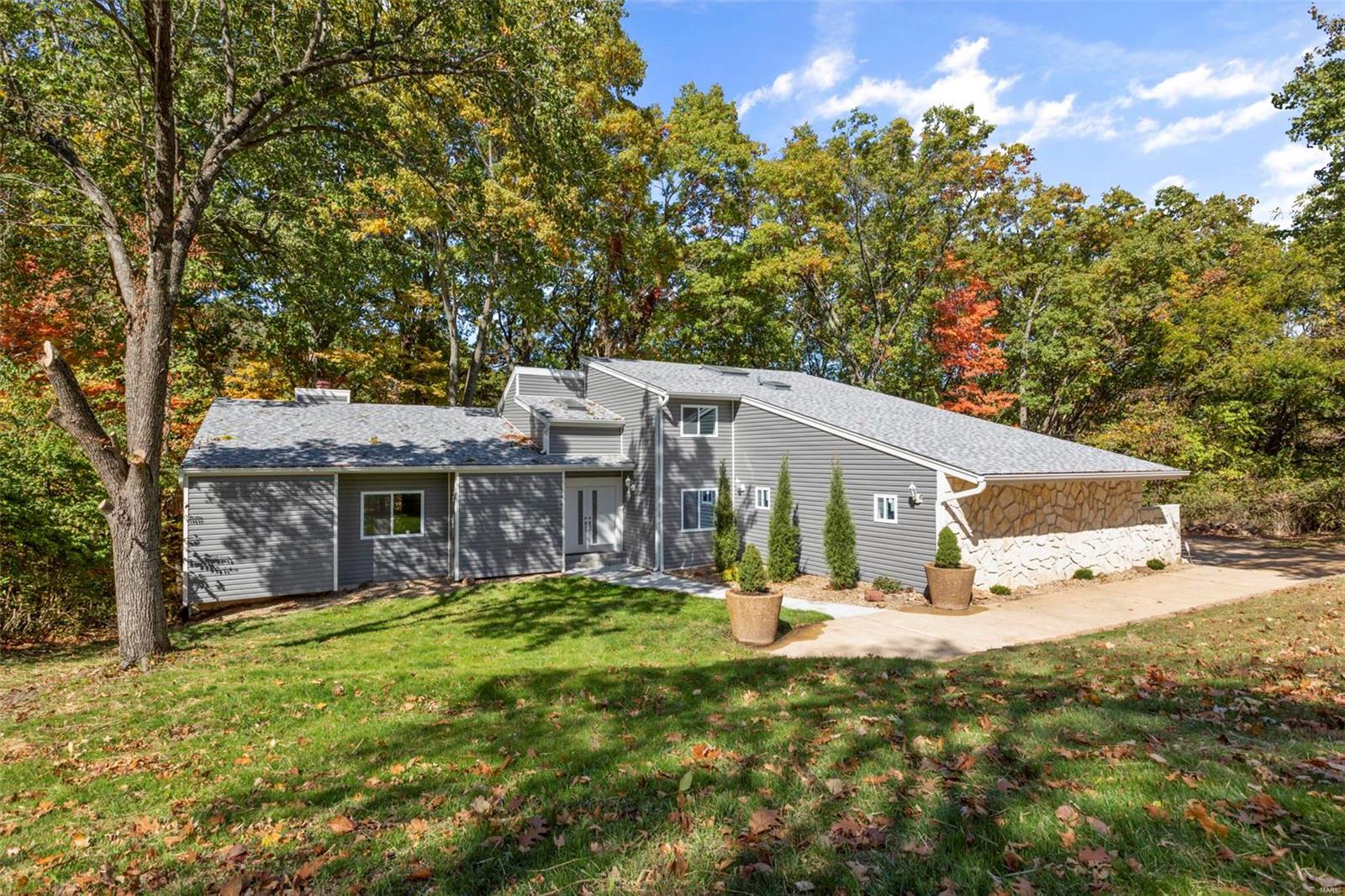 This is a beautifully renovated home on over 3 acres of a private wooded lot, a nature lover's dream! With 5 bedrooms and 4 bathrooms (3/1), there is plenty of space for a growing family. Step inside and you'll see new flooring, lighting, windows, carpeting, HVAC. A new kitchen with stainless appliances and granite counters has been nicely appointed for entertaining. The vaulted two story great room is accented by a wood burning fireplace. A main floor master also features a fireplace, a luxury bathroom, dual vanities, and a walk in shower with glass doors. Upstairs has two large bedrooms that share a full bathroom. The upstairs overlooks the living space of the main floor. The finished lower level has the fourth bathroom and two additional bedrooms. Outside is a peaceful retreat with expansive decks. Sit out and watch the wildlife forage. Additional features: new architectural shingle roof and siding. Owner financing or lease/purchase options are available to the new homeowner.
