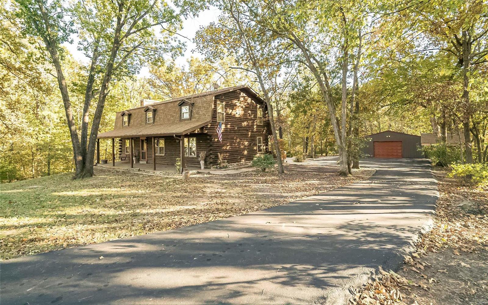 RARE FIND.  Unincorporated St Charles County with no HOA restrictions on 6+ PRIVATE ACRES in Wentzville schools.  This custom 2 story, FIVE BEDROOM, log home with side walk out lower level offers the rarity of location AND privacy.  Complete with large bonus room, cozy family room with wood burning fireplace, and a 50X30 m/l pole barn with 220 electric/2 man doors and concrete floor, you’ll LOVE your new home.  Imagine having coffee in the screened in back porch, not seeing another neighbor and hearing PEACE AND QUIET.  Plus, you don’t have to drive forever to get to shopping, restaurants and schools.  Just minutes from Wentzville and less than an hour from the airport.  LOCATION, PRIVACY AND QUALITY OF LIFE ARE ALL HERE.  Plan to visit soon.  We welcome you and we thank you.